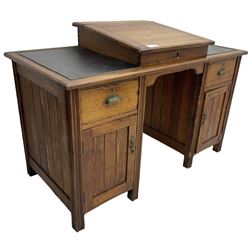 Edwardian pitch pine desk, rectangular top with writing slope flanked by inset leather writing surfaces, over twin pedestals each with shell cup handled drawer over cupboard, the left enclosing two shelves, the right enclosing sliding trays, on fluted straight supports