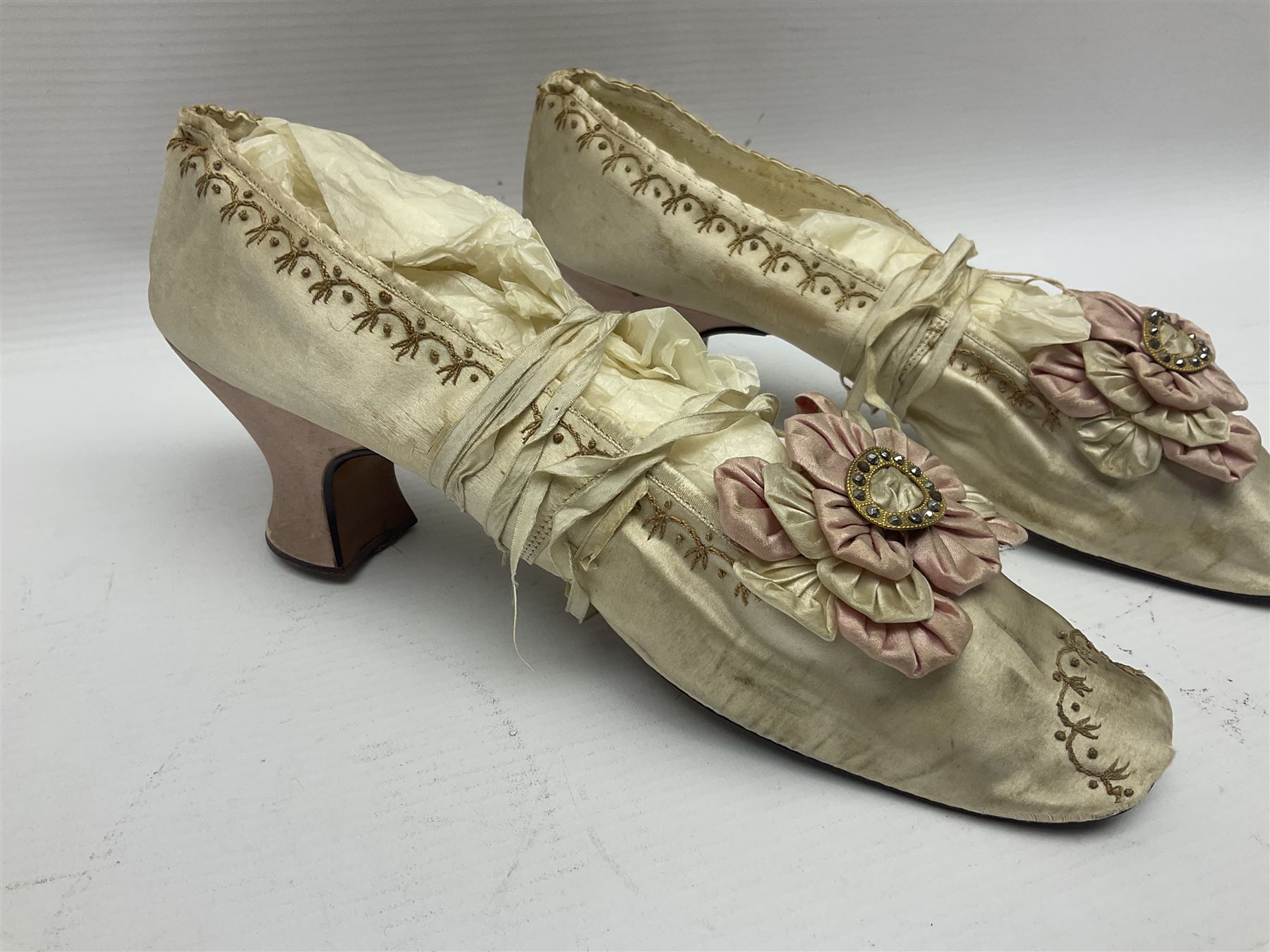 Pair of 19th century ivory silk satin ladies shoes, with rosette to the vamp, with pink silk satin heel, L23cm