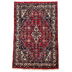 Persian Herati crimson ground rug, central ivory pole medallion surrounded by Herati motifs, with contrasting indigo spandrels, multi-band border with interlaced flowerheads