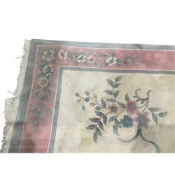 Chinese ivory ground washed woollen carpet, the field decorated with five large floral motifs with extending leafage, the wide rose guard band decorated with further floral patterns