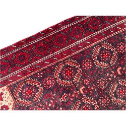 Persian Baluchi dark indigo and crimson ground rug, the field decorated with rows of repeating Pitrak motifs and surrounded by small bird and flower head motifs, floral urn decorated spandrels, repeating Pitrak border within guard stripes