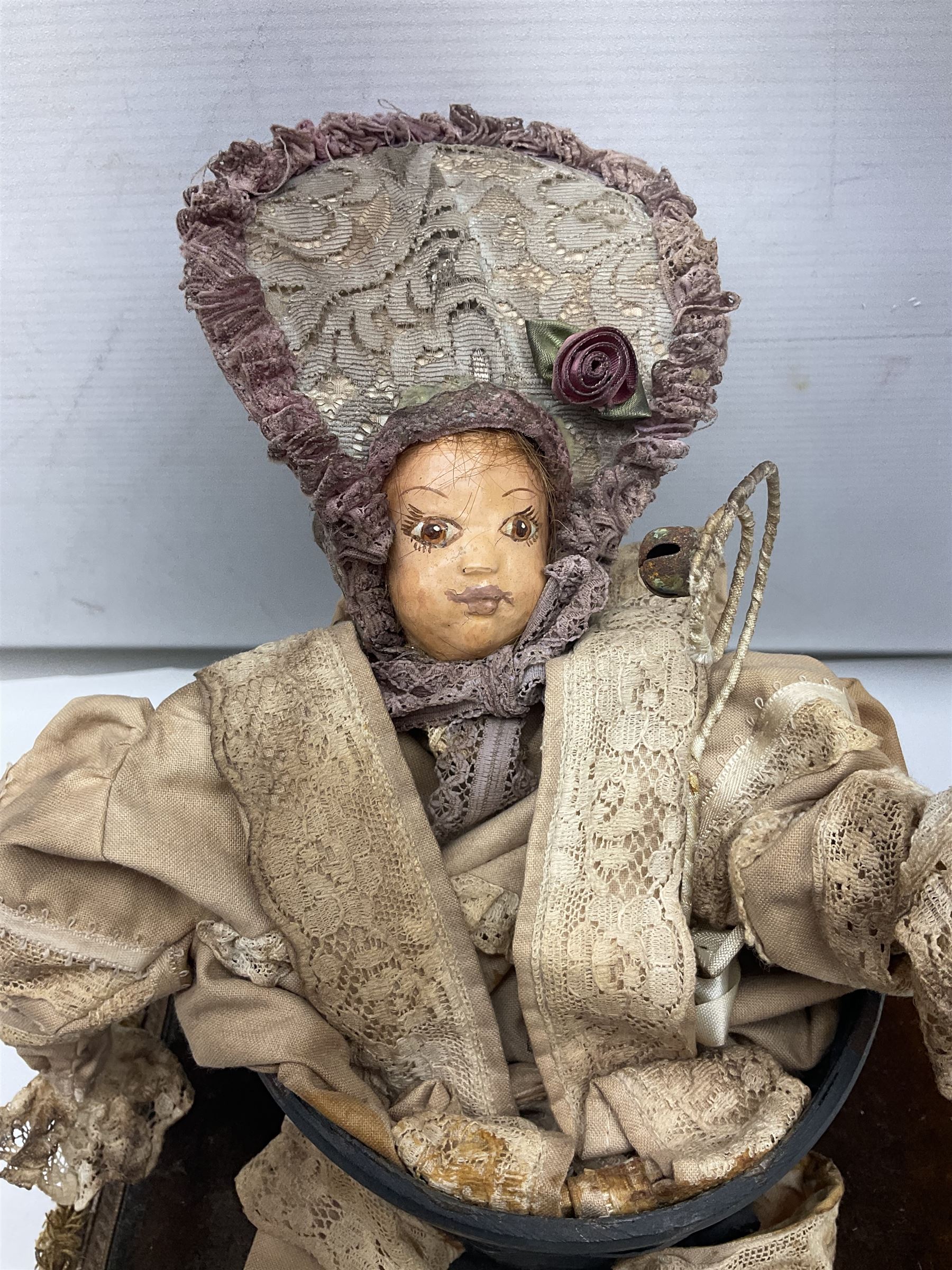 Modern reproduction automaton in the form of a baby doll in a basket clothed in Victorian style lace bloomers and frilled bonnet; clockwork action; on raised platform; with French paper label on base, 29cm wide,