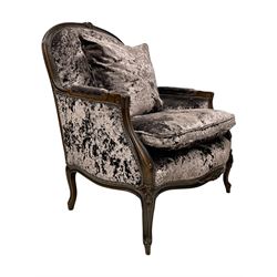 French design walnut framed wide-seat armchair, moulded frame carved with flowers, upholstered in purple crushed velvet, the lower rail carved with flowers and extending foliage, on cabriole feet