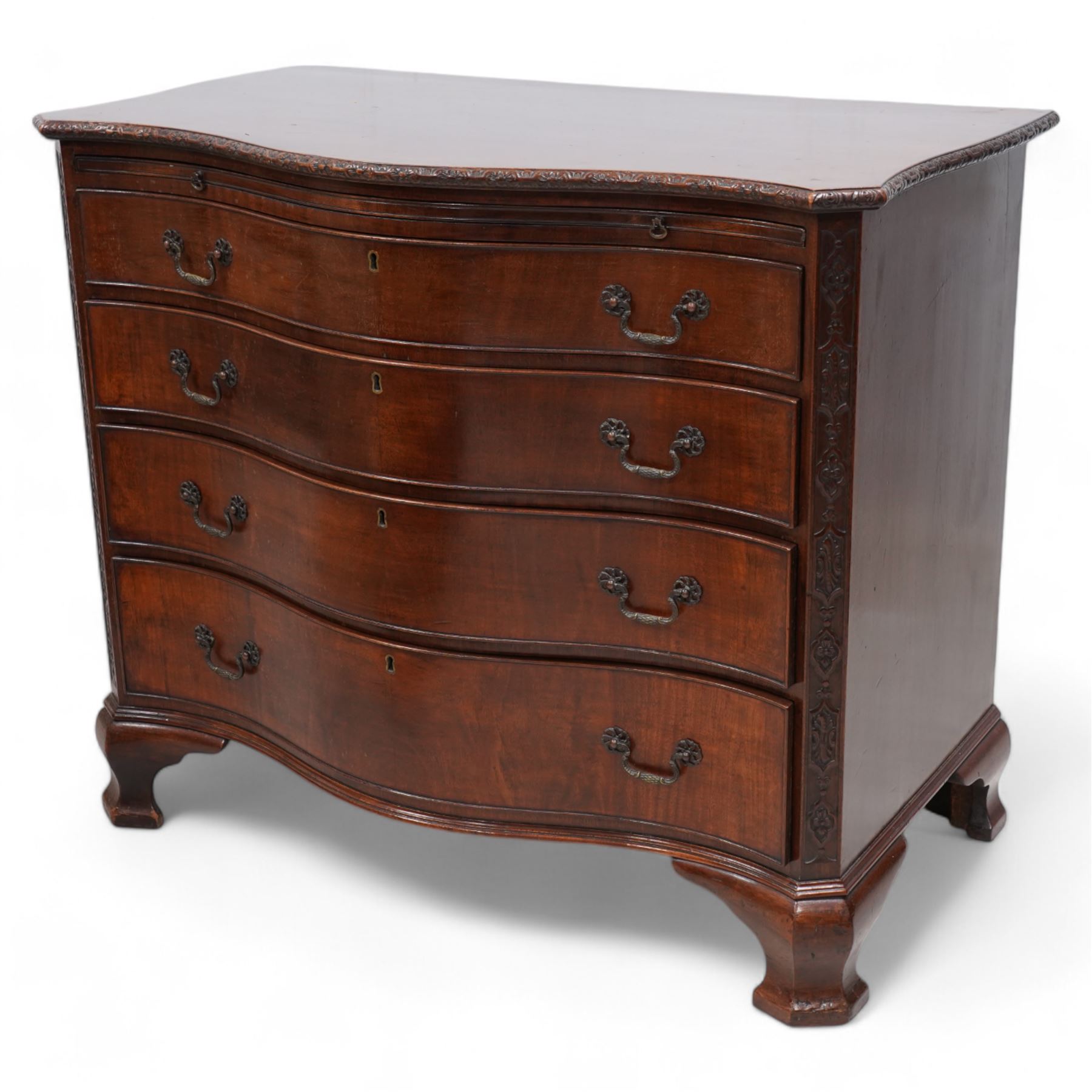 Early 20th century Chippendale design mahogany serpentine chest, shaped moulded top carved with repeating flower head motifs, fitted with brushing slide over four graduating cock-beaded drawers, pierced and foliate moulded handle plates with scrolled swan neck handles, canted upright corners carved with flower heads and strapwork, on canted ogee bracket feet