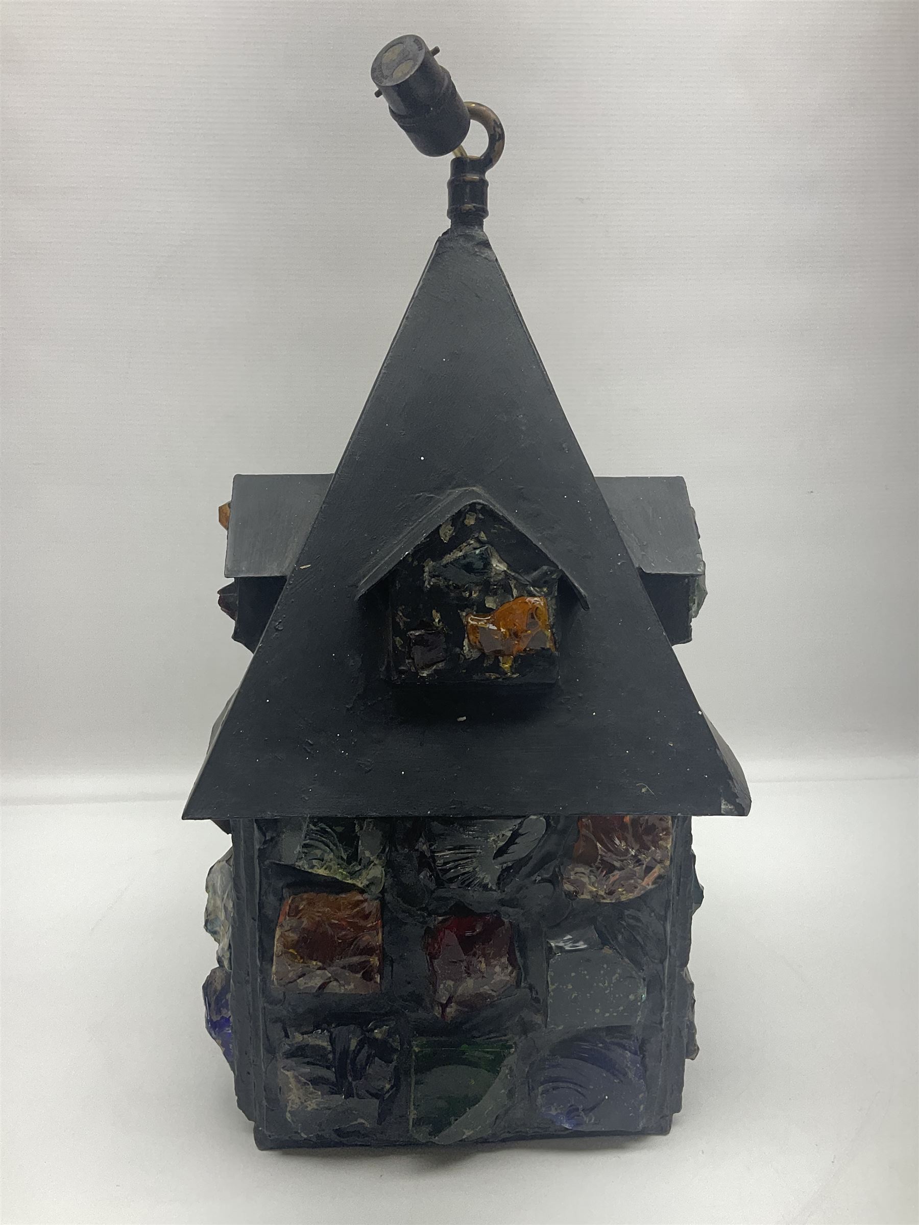 20th Century Arts & Crafts wrought iron porch lantern, in the manner of Peter Marsh, modelled as a house set with coloured resin panels, H38cm