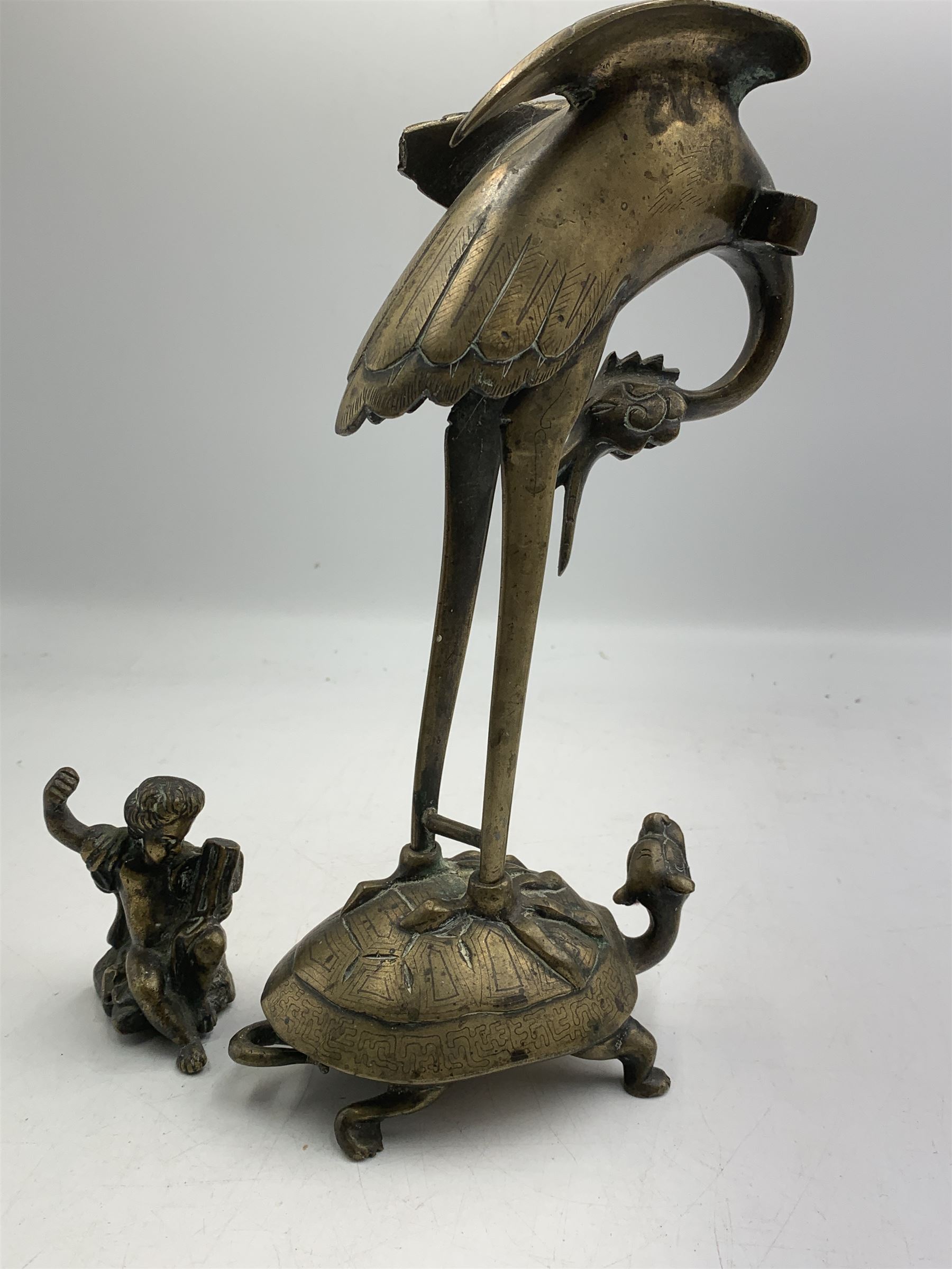 Early 20th century Japanese bronze figure or Okimono, modelled as a crane standing atop a turtle shell, possibly a candle holder, H25cm together with a small bronze figure modelled as a seated Cherub, H7cm (2)