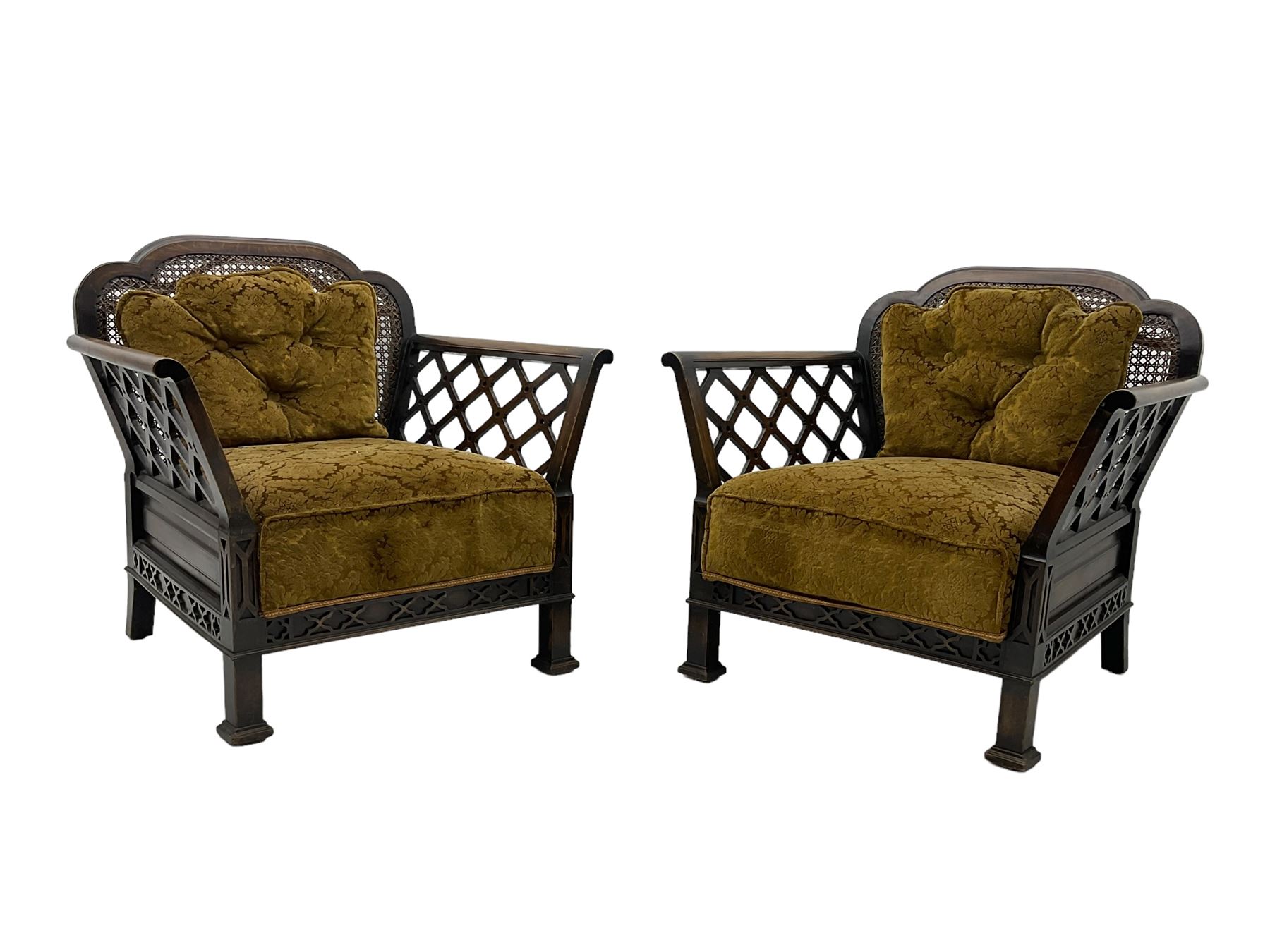 Early 20th century three-piece bergère suite - three seat sofa (W177cm, H82cm, D75cm); pair of matching armchairs (W84cm); single caned back with 'cock-pen' panelled arms, upholstered in foliate pattern fabric, blind fretwork lower frieze over square feet 