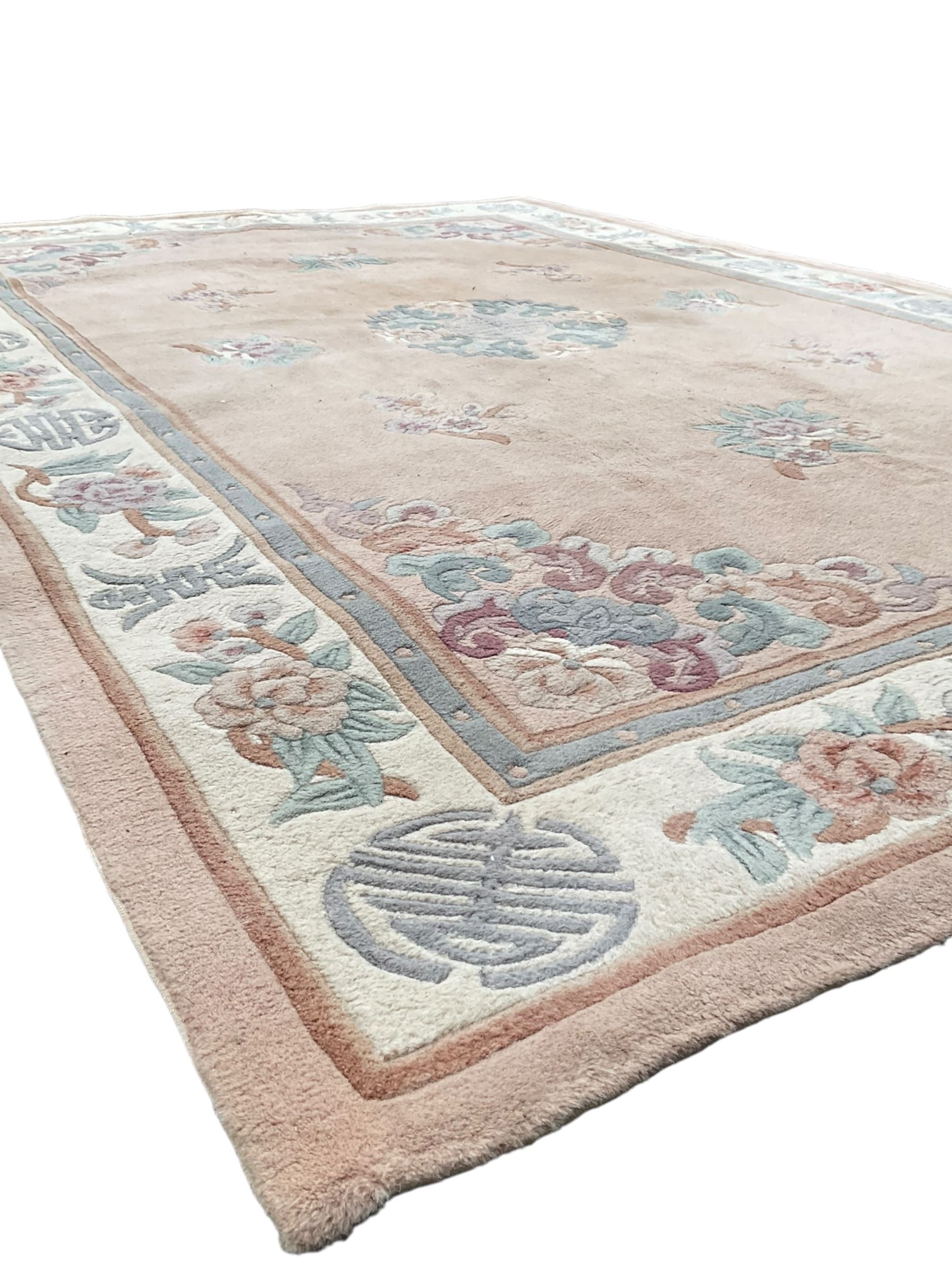 Chinese washed woollen pink ground rug, decorated with floral bouquets and Chinese symbols 