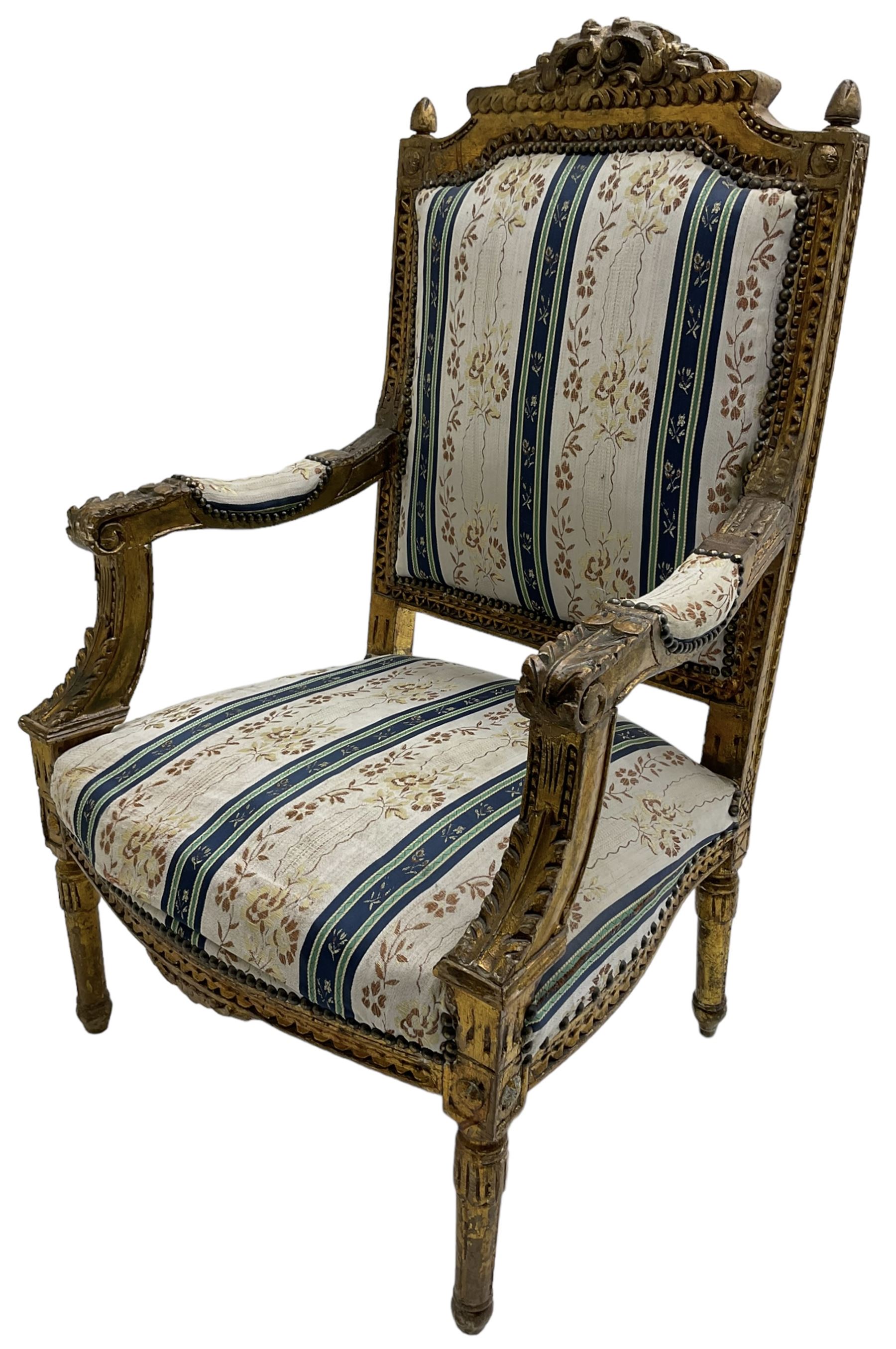 Late 20th century French design carved giltwood armchair, the cresting rail carved with scrolled foliage over foliate carved platform, upholstered in striped fabric decorated with trailing foliage and flower heads, acanthus carved arm terminals and upright supports, on turned and fluted supports 