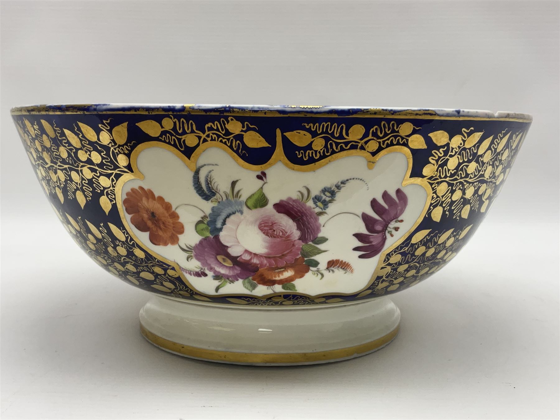 19th century continental bowl, decorated with hand painted floral sprays amongst gilt foliate decoration on a cobalt blue ground, D27.5cm