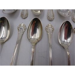 Two sets of twelve late 19th/ early 20th century American silver coffee spoons, the first set with engraved initial to terminal within scrolling border and engraved date verso, the second set with embossed floral decoration to handles, all stamped Sterling 