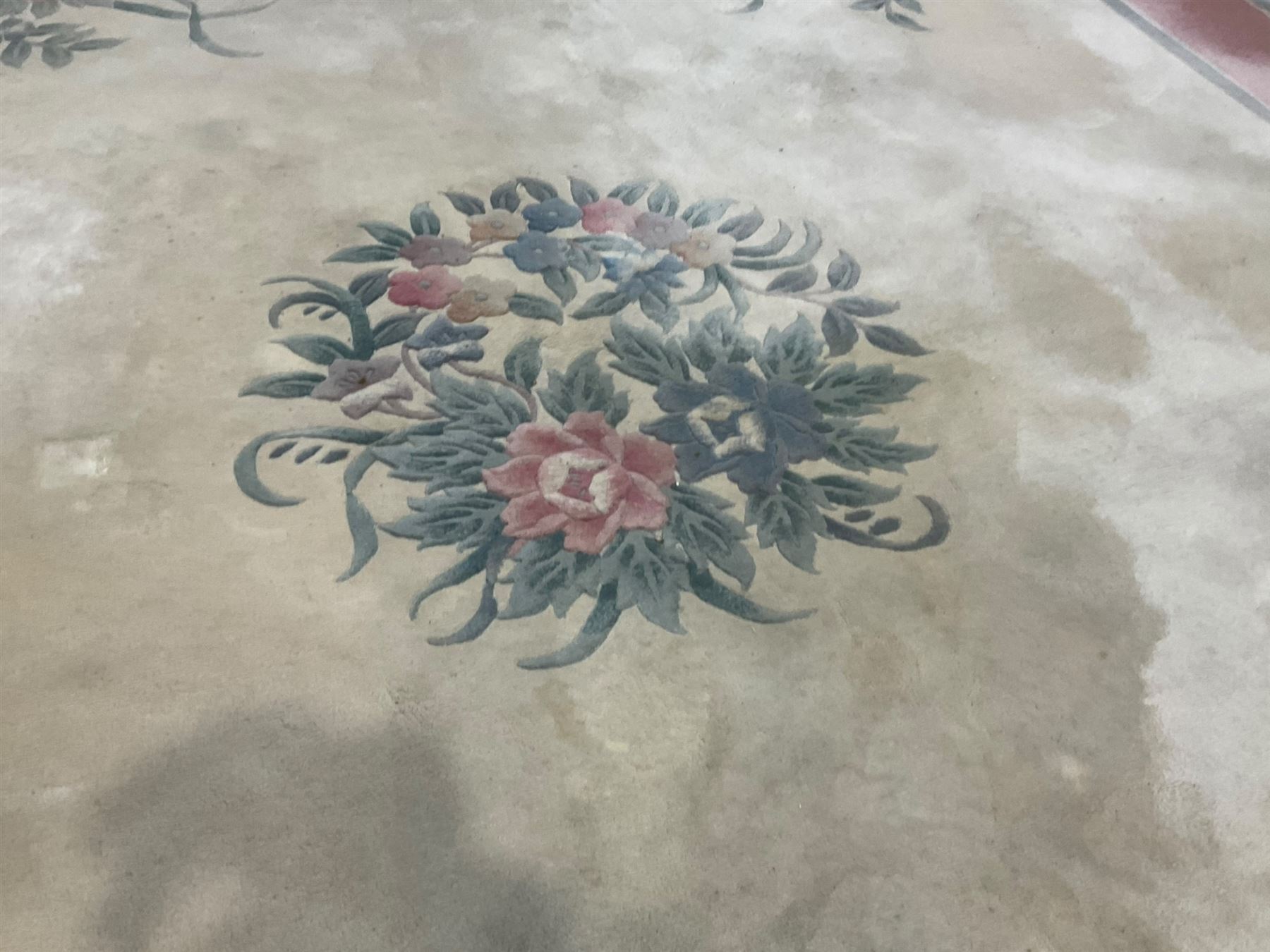 Chinese ivory ground washed woollen carpet, the field decorated with five large floral motifs with extending leafage, the wide rose guard band decorated with further floral patterns