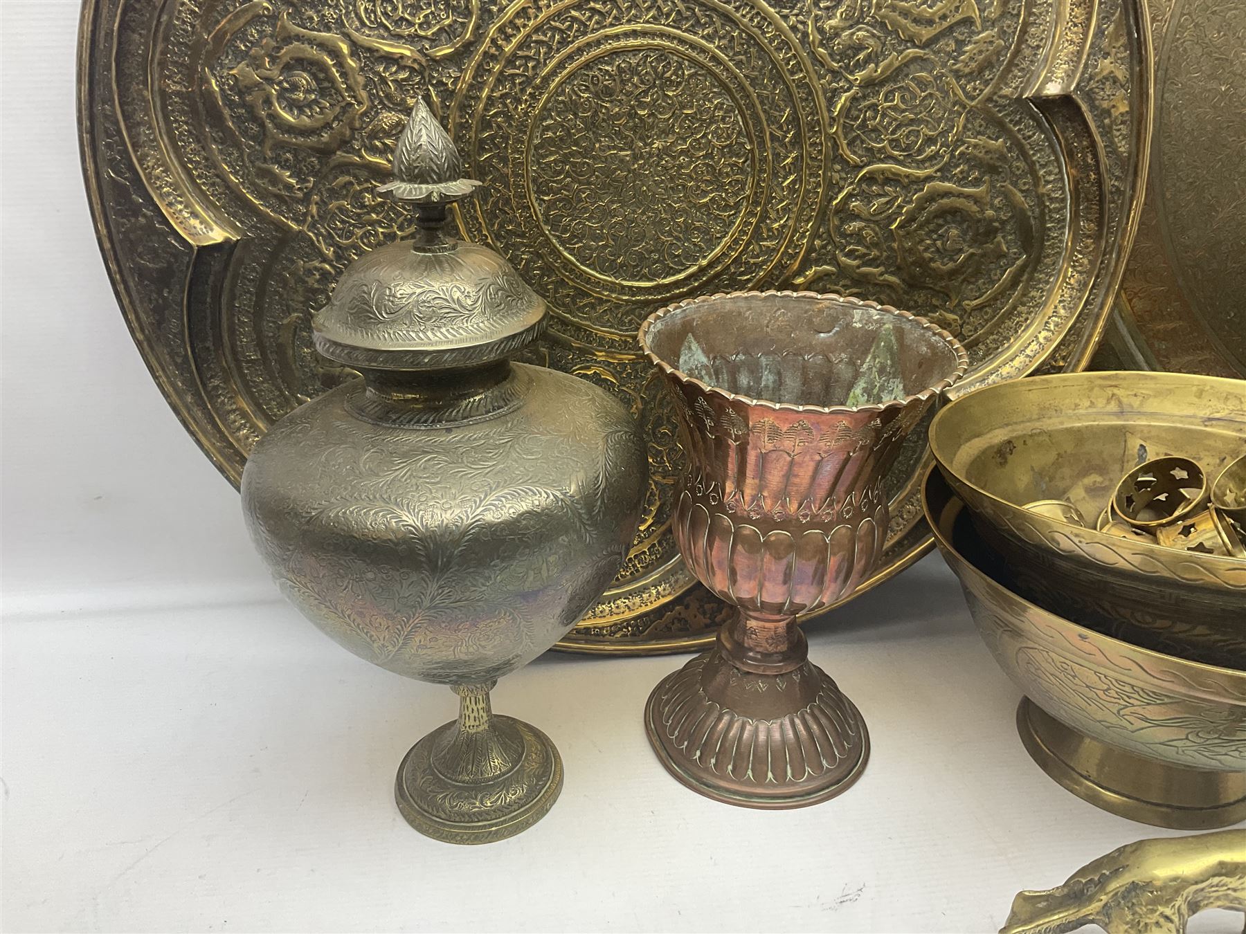 Collection of oriental brass and other metal ware, to include to large chargers, pair of covered urns, hoho bird, etc, largest charger D63cm