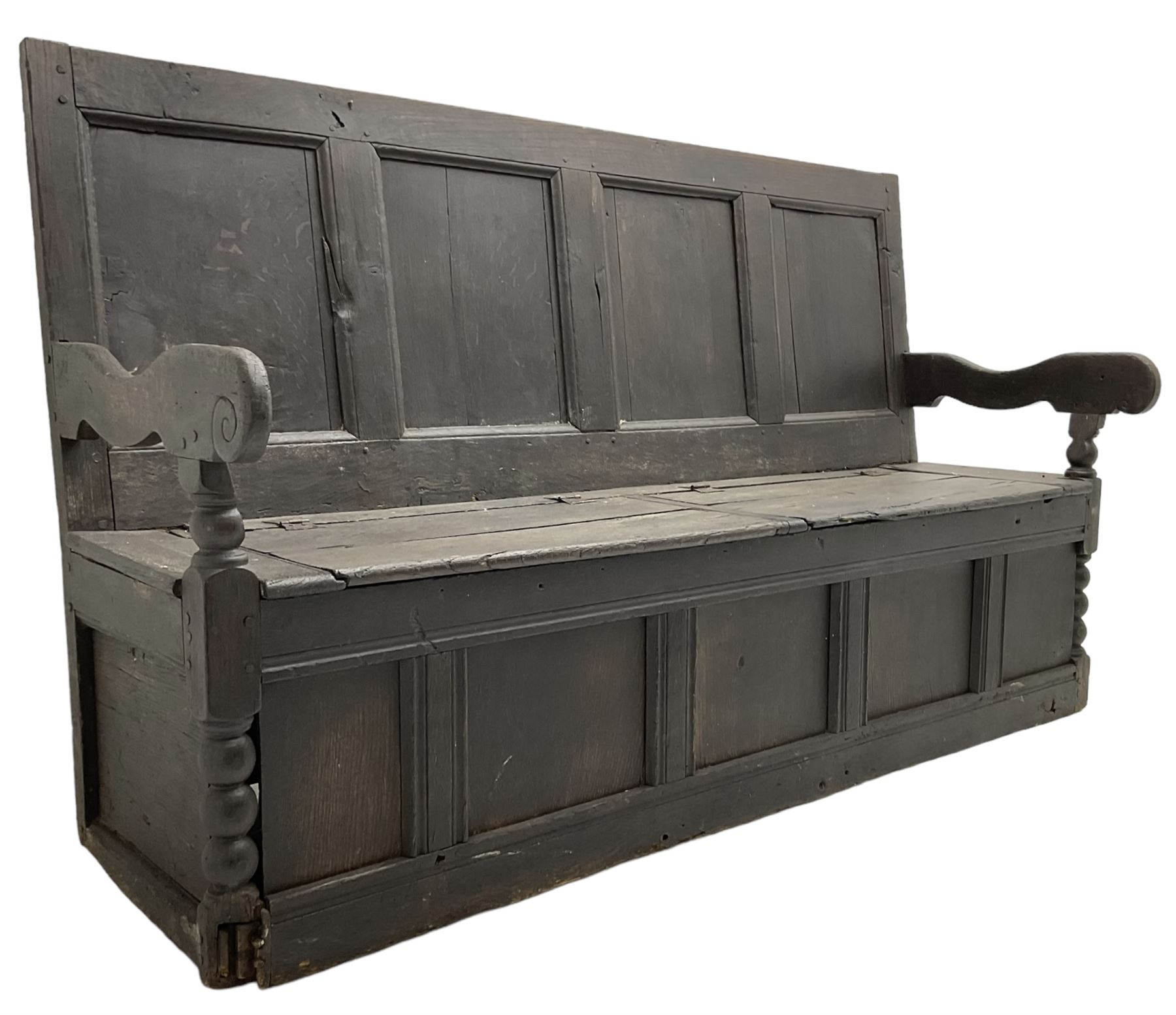 18th century oak box seat settle bench, pegged construction with quadruple panelled back over double hinged box seat, shaped projecting arms with scroll carved terminal detail, on block and bobbin turned front supports, panelled front within moulded frame