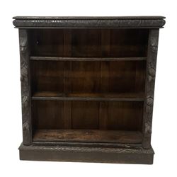 Victorian Jacobean revival carved oak open bookcase, cushion frieze carved with foliate decoration the pilasters decorated with applied carved lion masks and fruit motifs with extending leafage, two shelves over skirted base