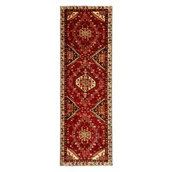 Persian crimson ground rug, the field decorated with three medallions within stepped borde...