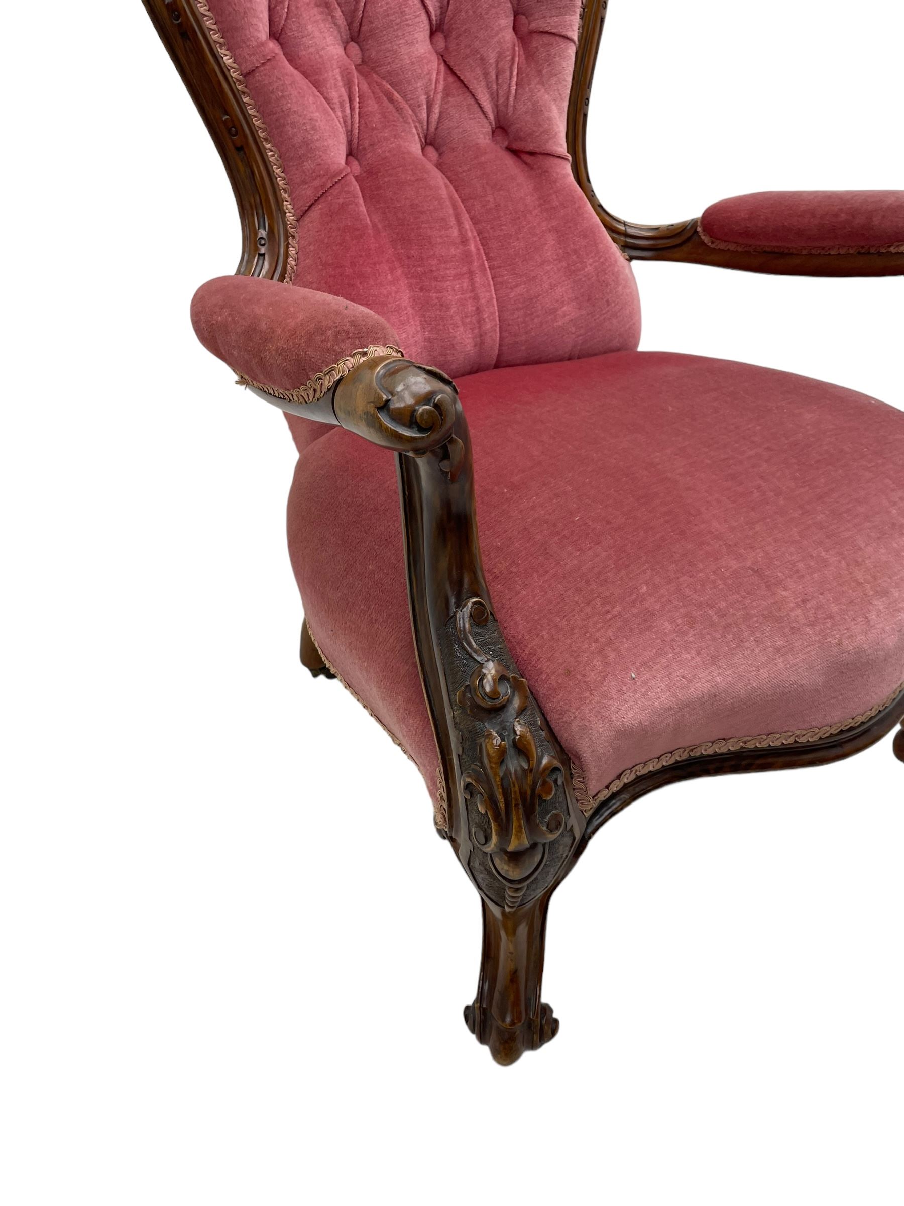 Victorian carved walnut open armchair, foliate carved cresting rail over butted back and sprung seat, upholstered in pink velvet scrolled arm terminals with moulded scrolling vines terminating to cabriole supports and ceramic castors