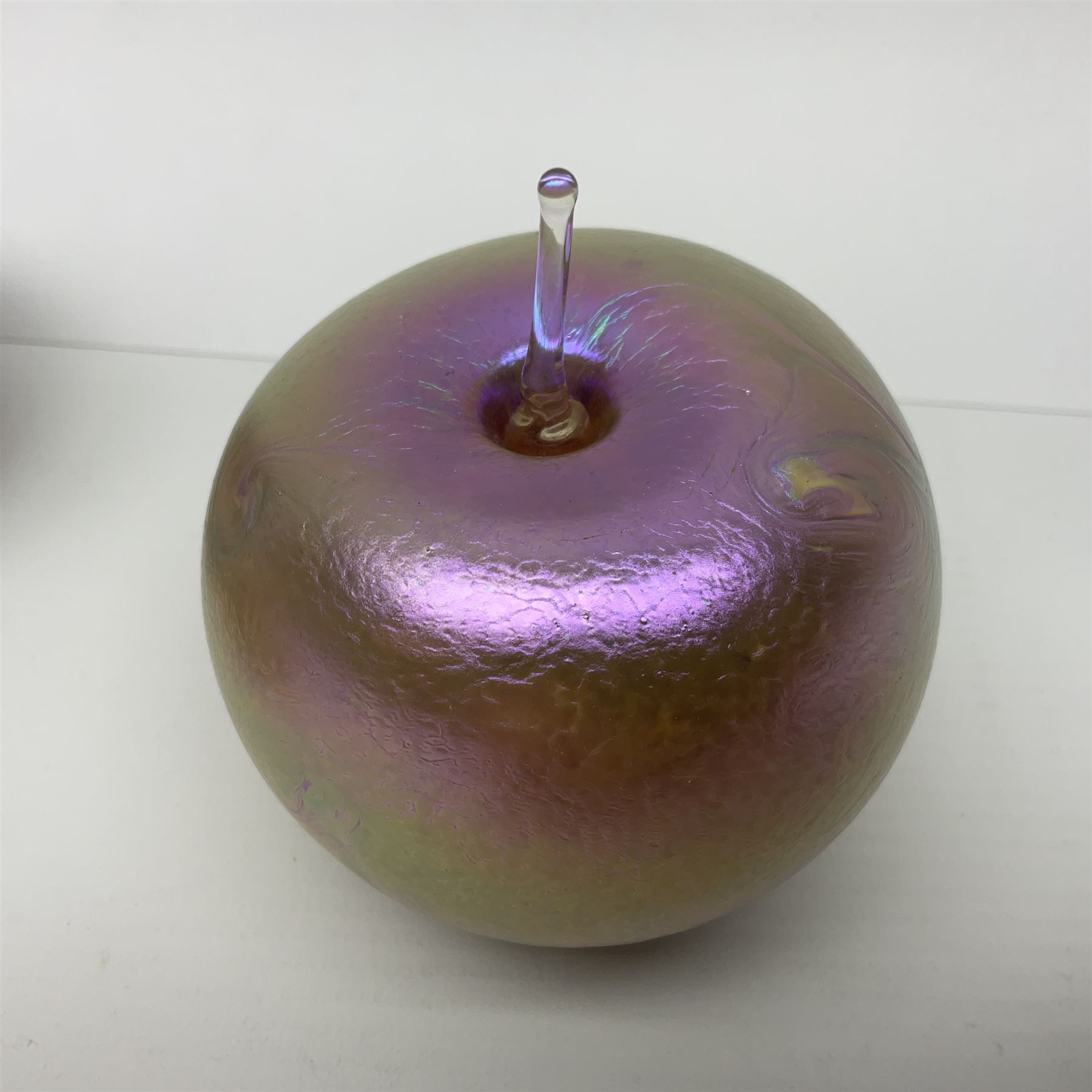 Four Okra scent bottles, the first example modelled as an apple, the second of squat form decorated with iridescent threads upon a gold ground and two others 