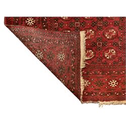 Antique Persian crimson ground rug, the field decorated with Gul motifs, the guarder border with stylised stars in ivory and dark indigo