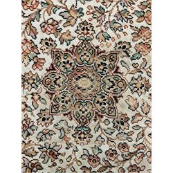 Large Persian design carpet, overall floral design, the field decorated with large rosette motifs surrounded by trailing foliate motifs, the border decorated with trailing branch and stylised plant motifs