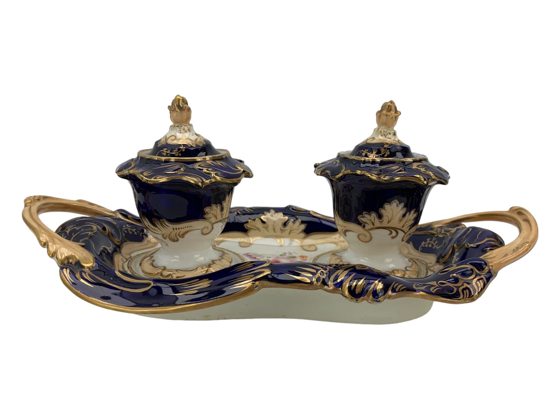 19th century porcelain inkstand, the oblong twin handled base centrally painted with a floral bouquet, flanked by two footed inkwells and covers, with rococo-inspired acanthus moulded borders and handles, pattern no. 2/3339, L26.5cm 