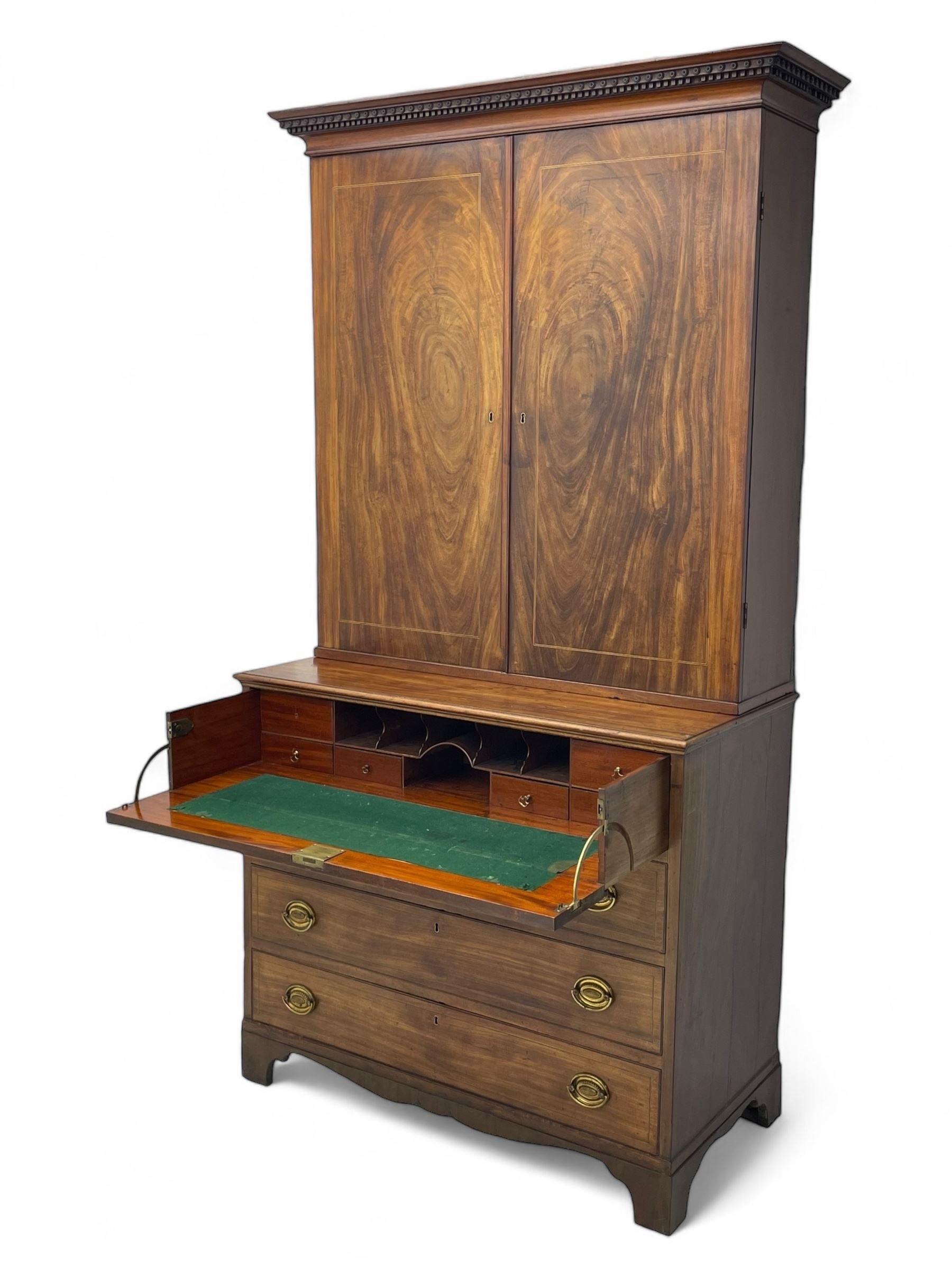 George III figured mahogany secretaire bookcase, projecting moulded dentil cornice decorated with single row of roundels, two figured mahogany doors with boxwood and ebony stringing enclosing three adjustable shelves and three drawers, moulded rectangular top over four long scratch-moulded drawers, the top secretaire drawer with fall front enclosing small drawers, pigeon holes and inset writing surface, shaped apron with bracket feet