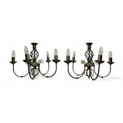 Pair of brass five-branch chandeliers, each featuring scrolling arms with candle-style lig...