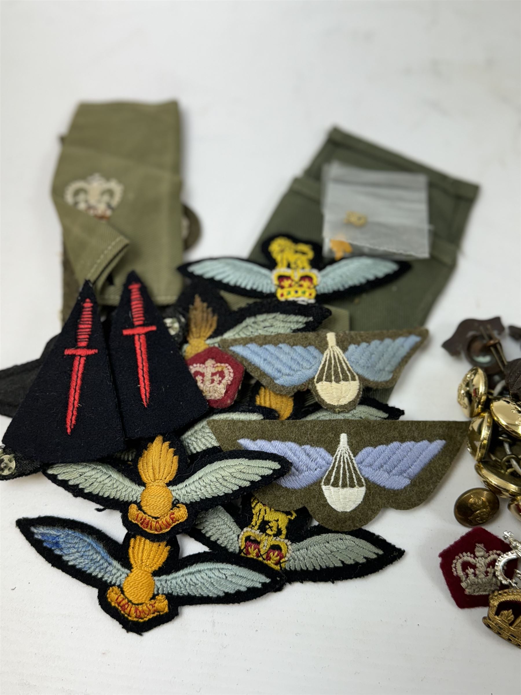 Various cloth and metal military badges including cap and collar badges, rank crowns and stars, staybrite button etc