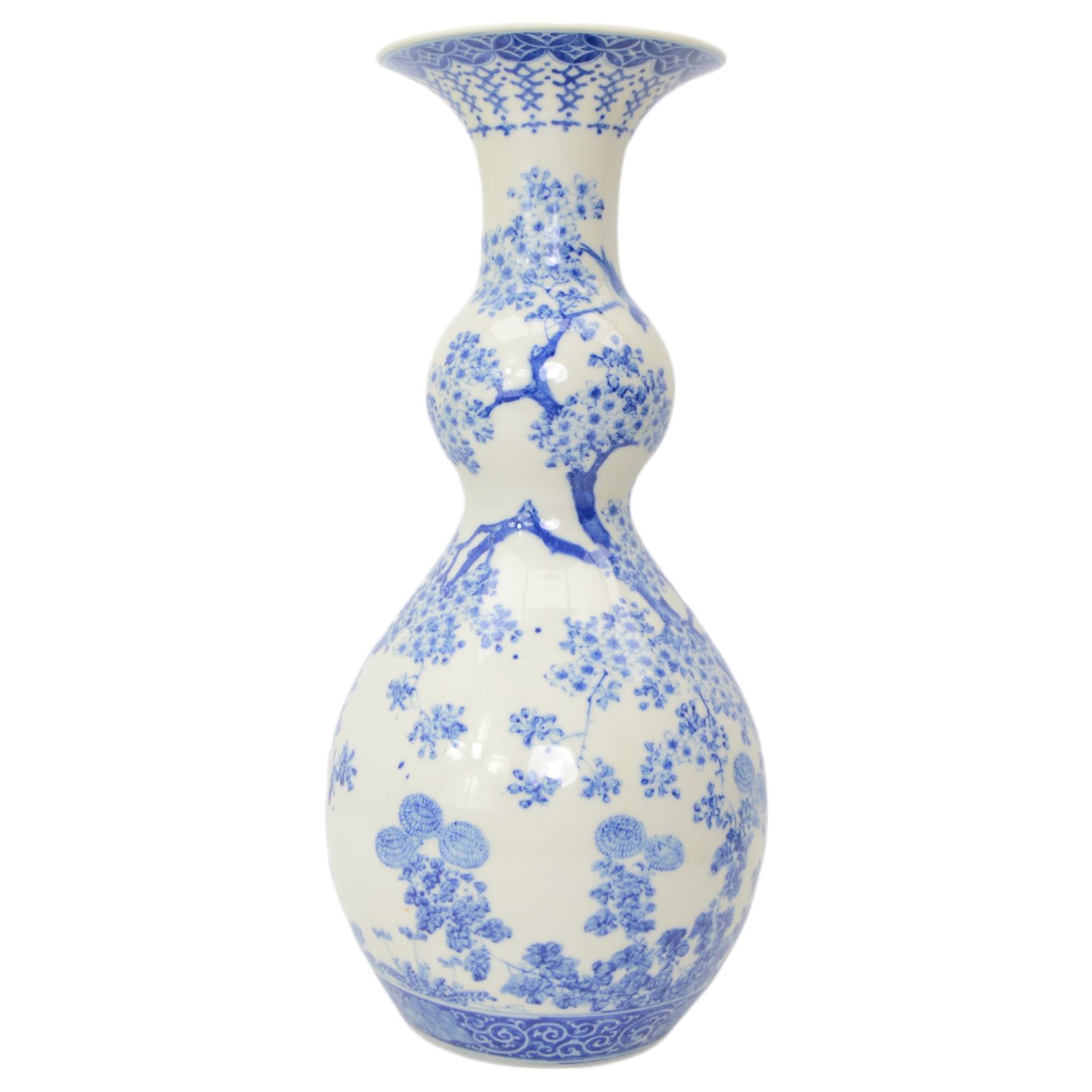 Japanese Meiji period porcelain double gourde vase, painted in blue with birds perched on a blossoming tree, within scroll and foliate borders, impressed seal mark beneath, H43.5cm 