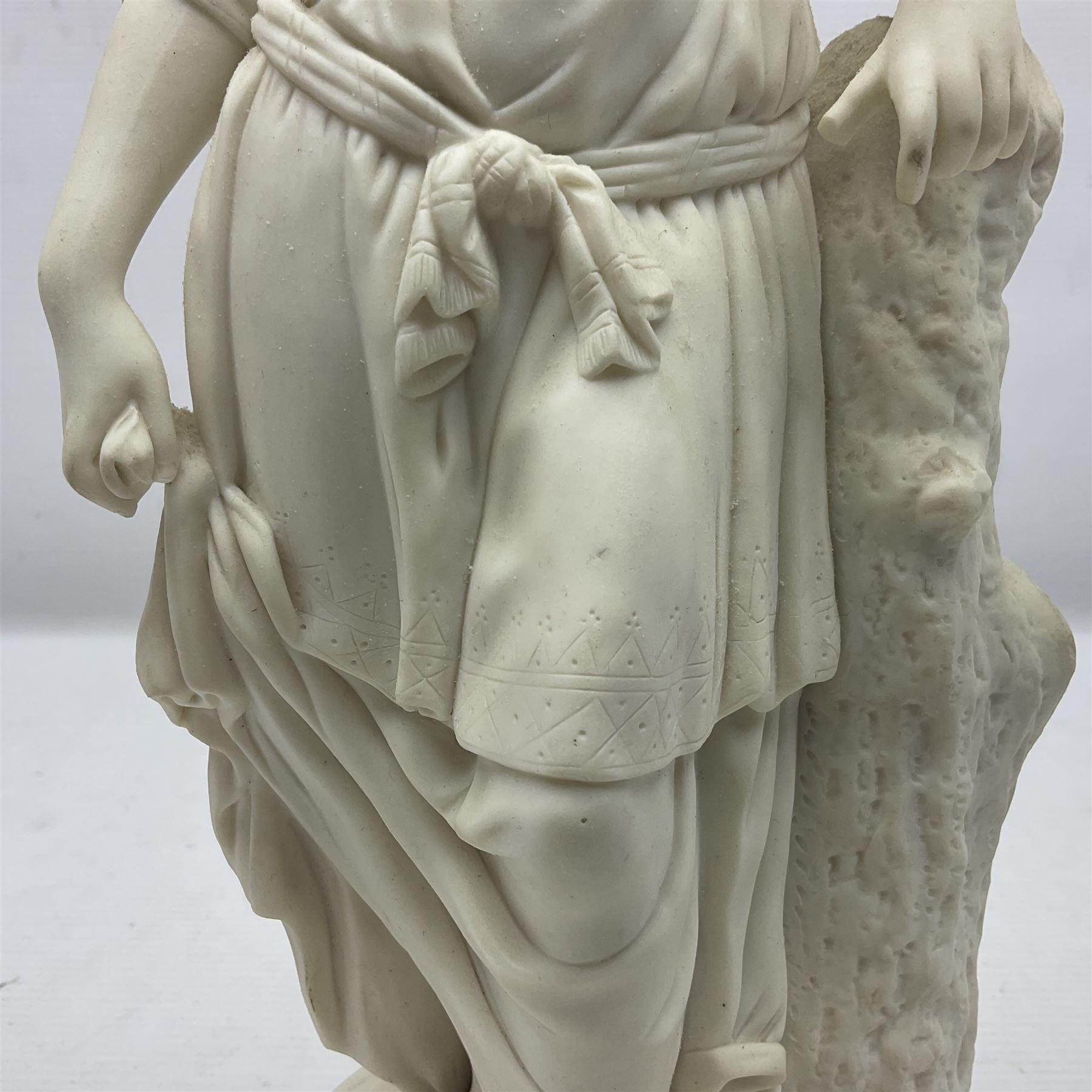 Parian figure modelled as a female in classical dress leaning upon a tree stump, H36cm