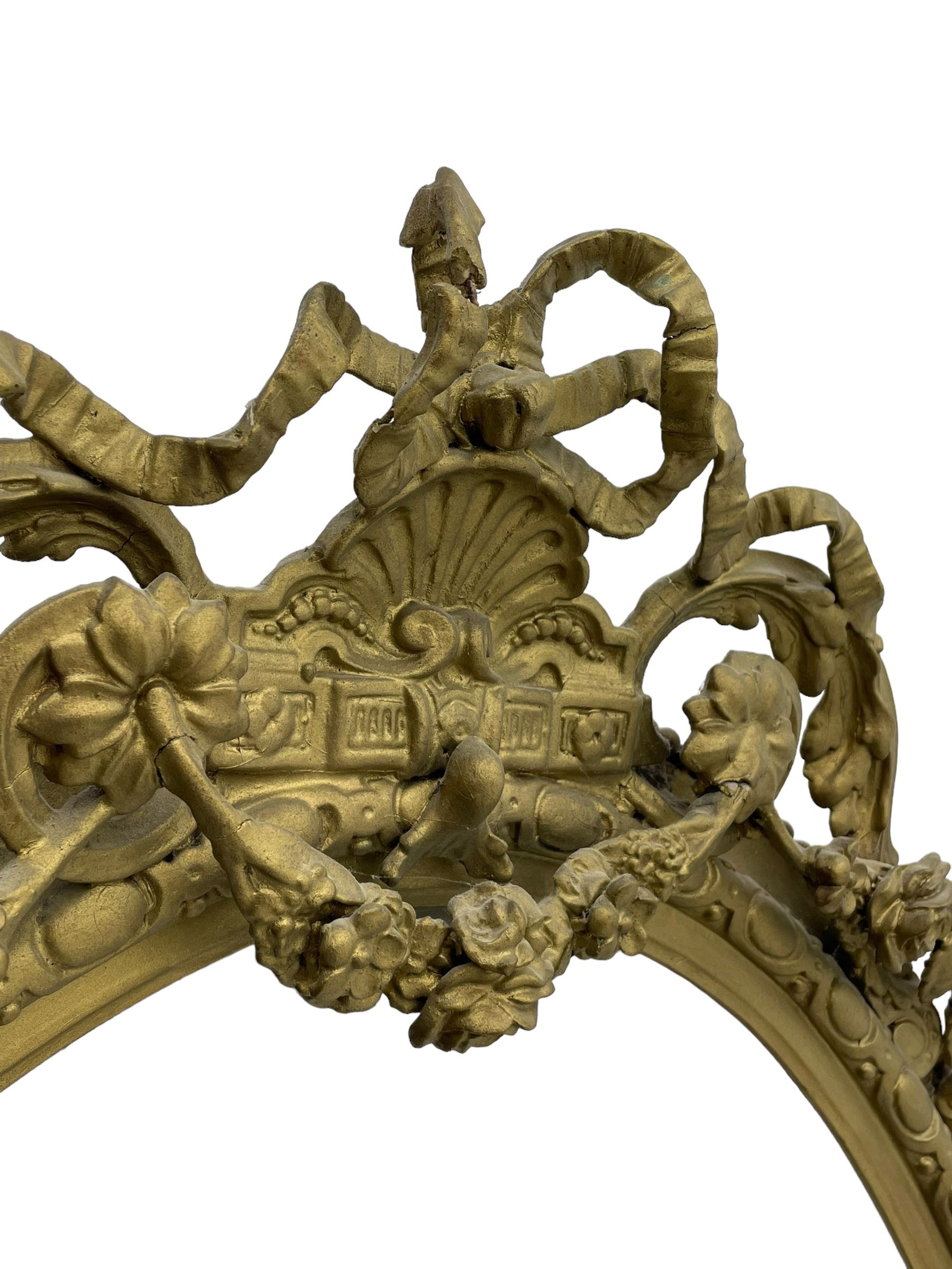 19th century giltwood and gesso girandole wall mirror, the raised pediment decorated with ribbon tie over curled acanthus leaves and flowerhead festoons, oval egg and dart moulded frame with outer bead, three projecting candle sconces in the form of scrolled acanthus leaves, lower shell motif with extending leaf decoration 