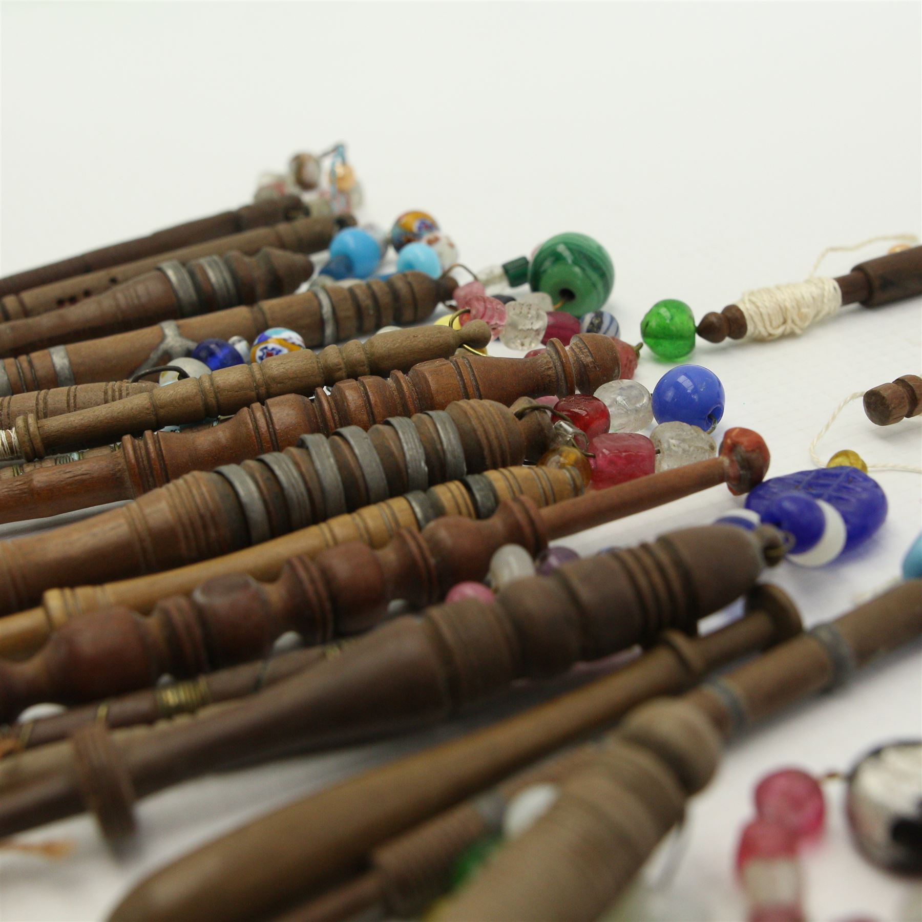 Collection of turned wooden lace maker's bobbins, including 19th century and later examples, two mother & babe carved bobbins etc, mostly with glass spangles (87 approx)