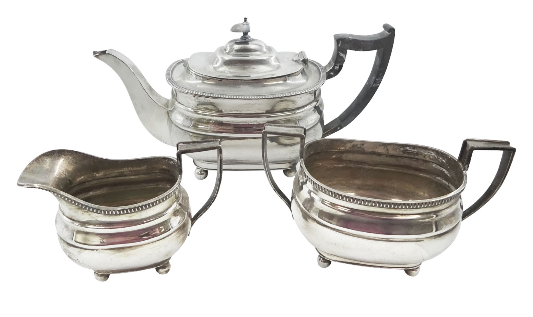 1930s silver three piece tea service, comprising teapot, open sucrier and milk jug, each of oval form with oblique gadrooned rim, the teapot with Bakelite handle and finial, hallmarked James Dixon & Sons Ltd, Sheffield 1932