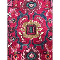 Persian Nanaj crimson ground carpet, the busy field filled with interconnecting stylised plant motifs with scrolling branches, the guarded indigo border decorated with repeating palmettes and foliate patterns