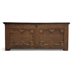 18th century oak blanket box, rectangular form with a hinged lid, the front decorated with raised geometric panelled mouldings, fitted with a central lock plate, raised on bracket feet