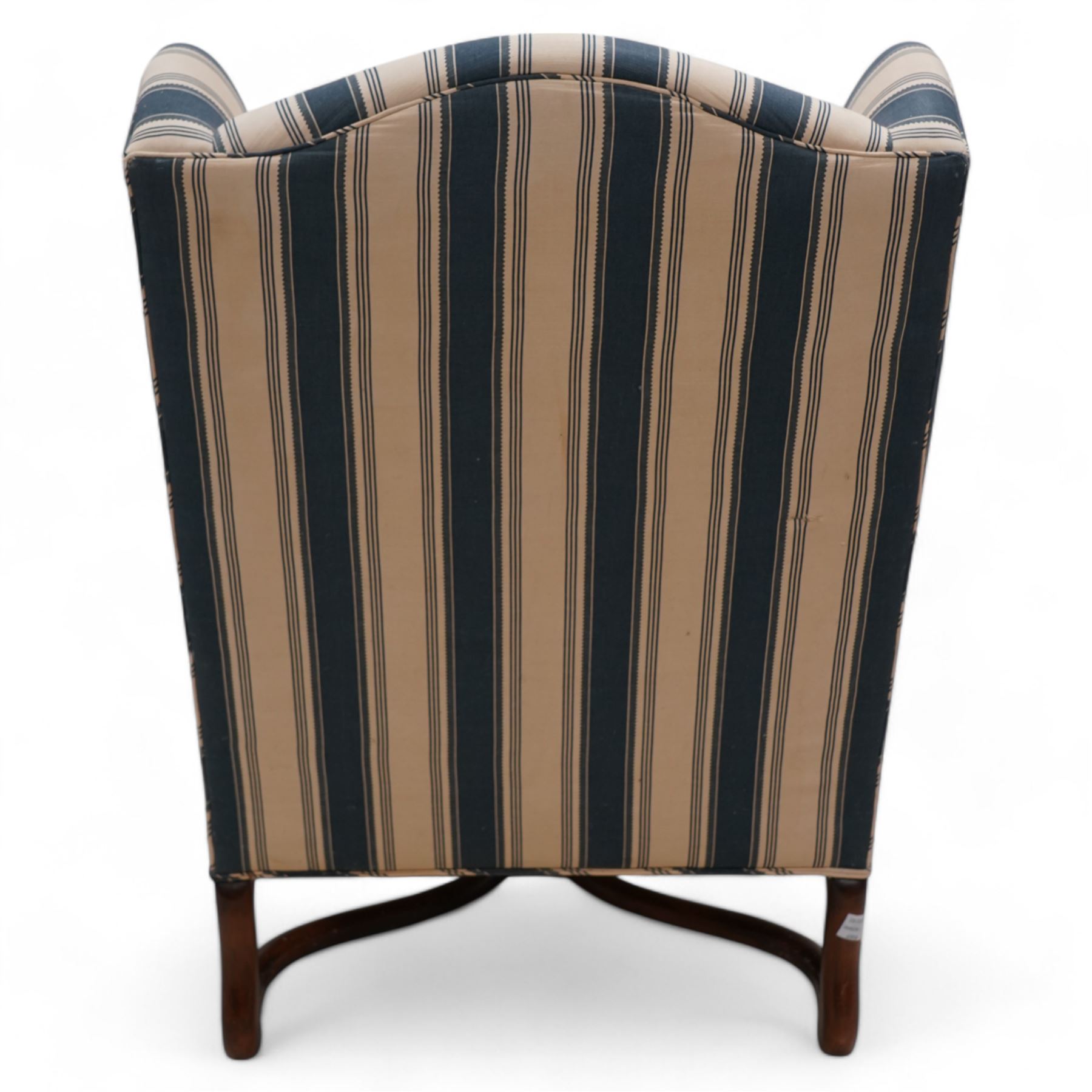 Georgian design wingback armchair, upholstered in blue and cream striped fabric, on shaped supports united by serpentine x-framed stretchers 