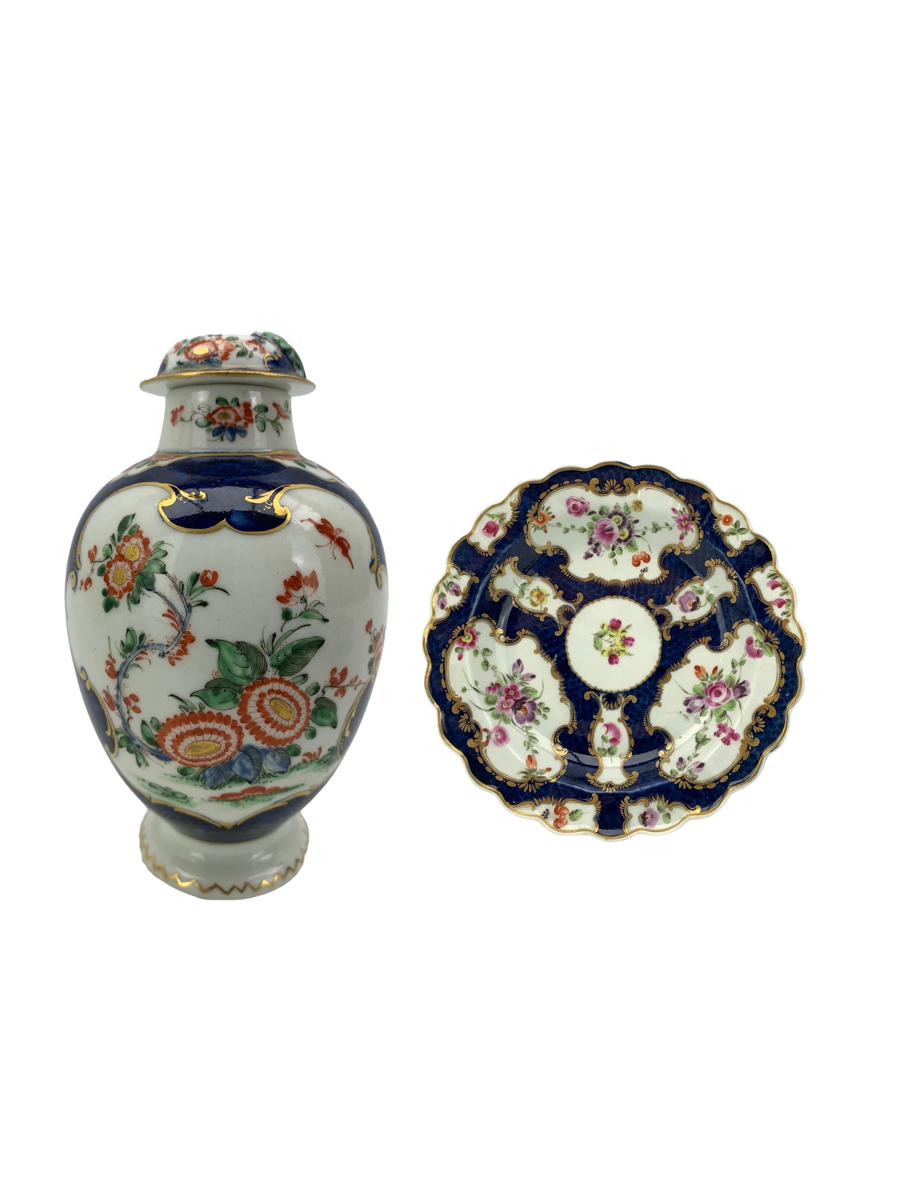 18th century Worcester tea caddy, of oval form and painted in the Kakiemon palette with reserves of flowers against a blue scale ground, H14cm together with a similar Worcester circular dish, painted with floral sprays, within a scalloped edge, blue crescent mark beneath, D19cm (2)