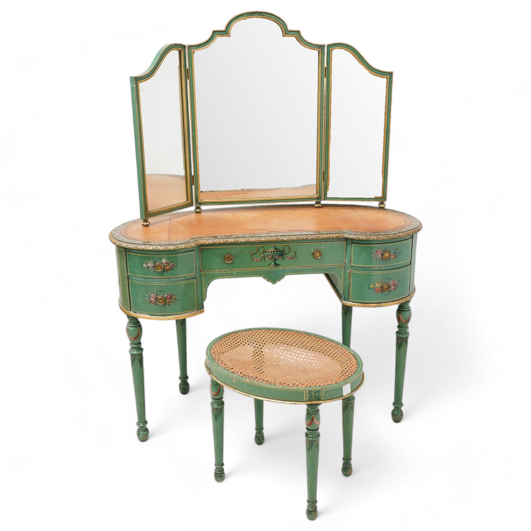 Edwardian Adam Revival green-painted and parcel gilt kidney-shaped dressing table, raised triple mirror back with shaped cresting, leather inset top within a trailing floral painted band and foliate carved edge, fitted with five drawers decorated with urn and floral bouquets, on turned supports painted with acanthus leaves and draped festoons; together with matching stool with cane seat 