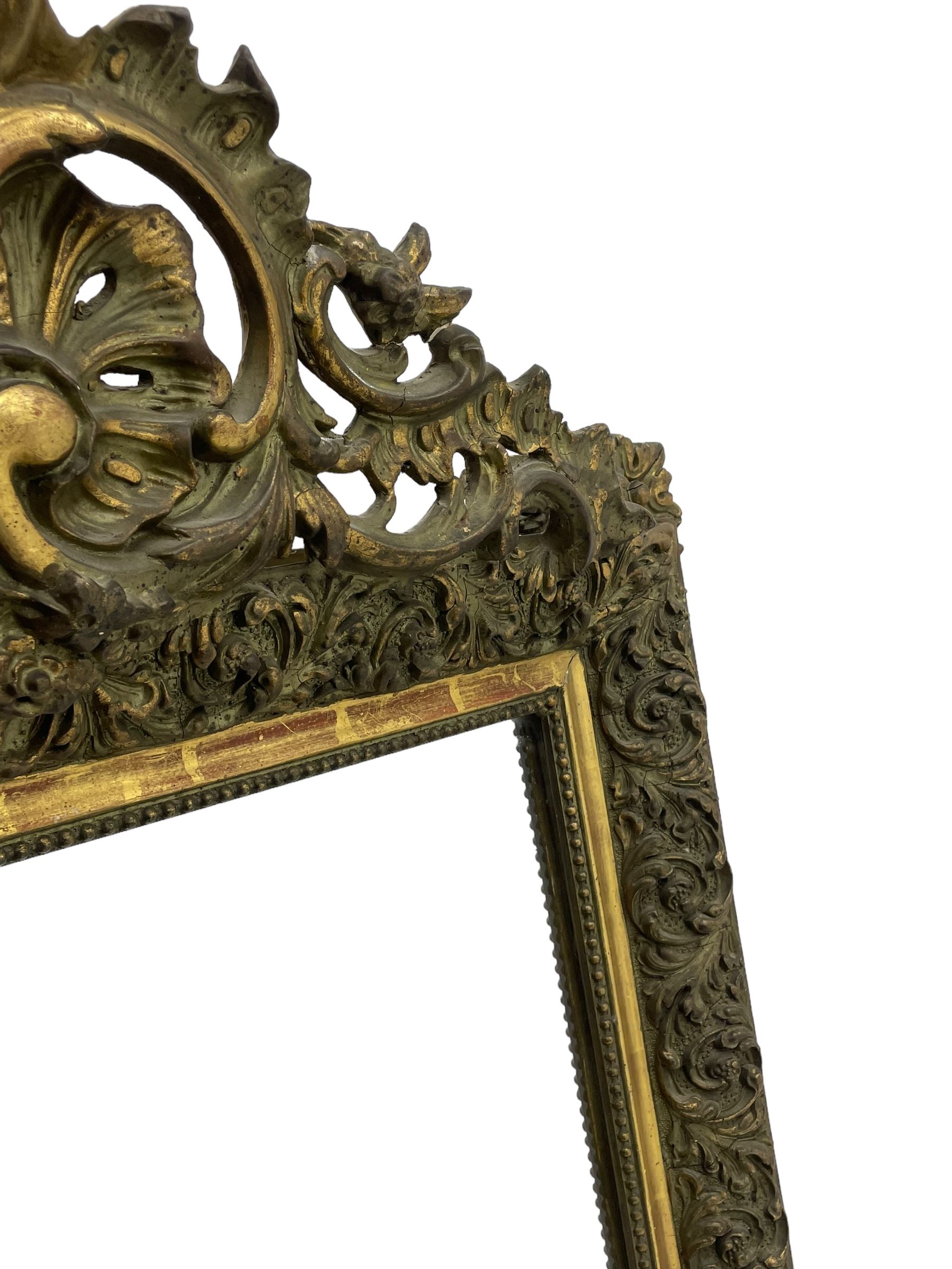 Victorian giltwood and gesso wall mirror, pierced shell cartouche pediment decorated with C-scrolls and curled leaves, moulded frame with curled acanthus leaf decoration and beaded inner slip, the corner brackets decorated with flower heads 