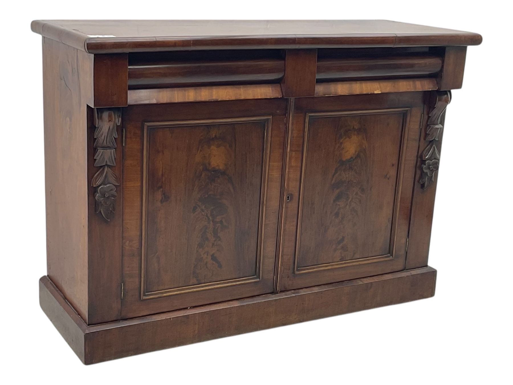 Mid 19th century mahogany sideboard, rectangular top over two frieze drawers with rounded edges, flanked by floral carved corbels, over two panelled cupboard doors, raised on a plinth base