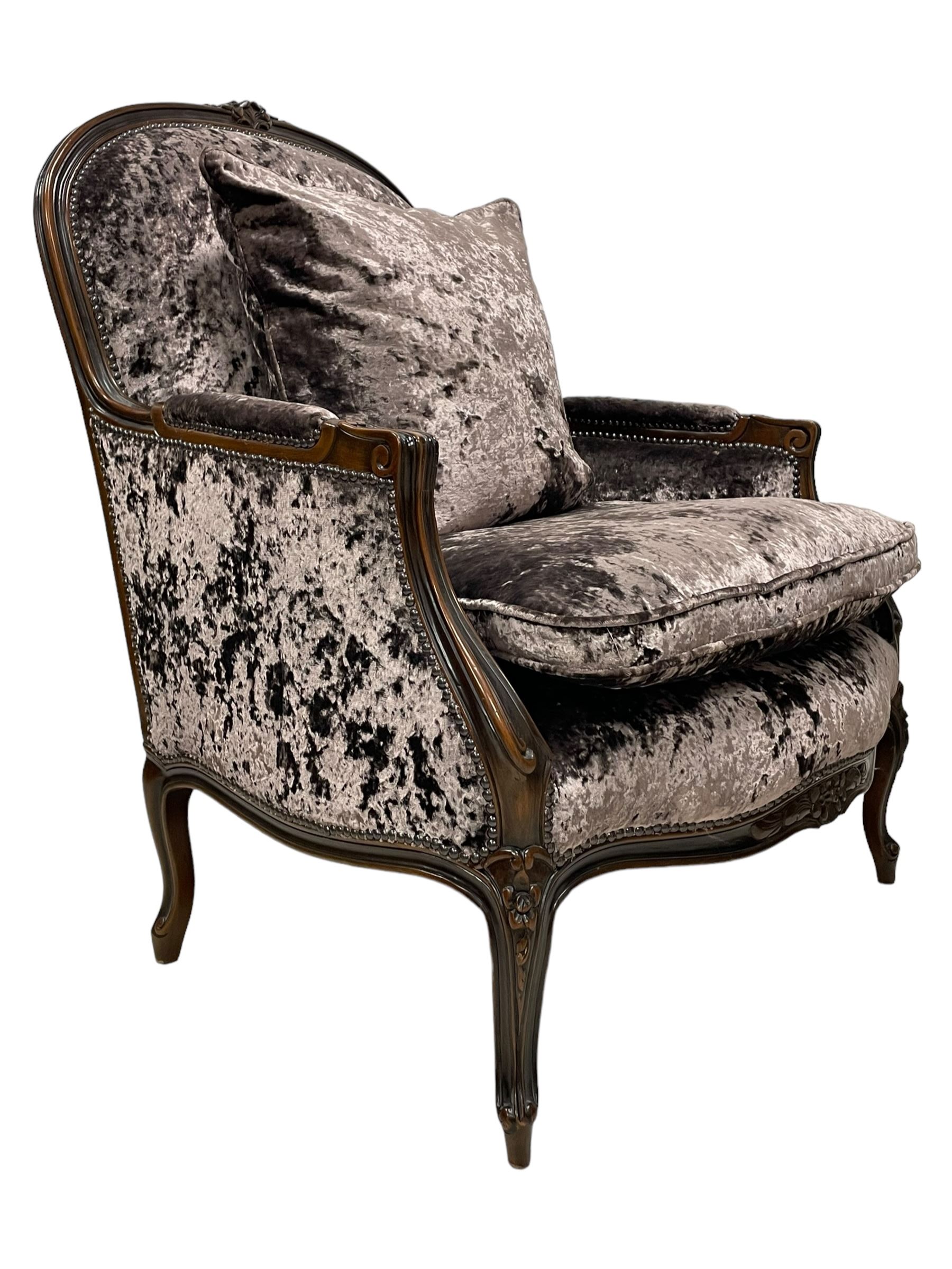 French design walnut framed wide-seat armchair, moulded frame carved with flowers, upholstered in purple crushed velvet, the lower rail carved with flowers and extending foliage, on cabriole feet