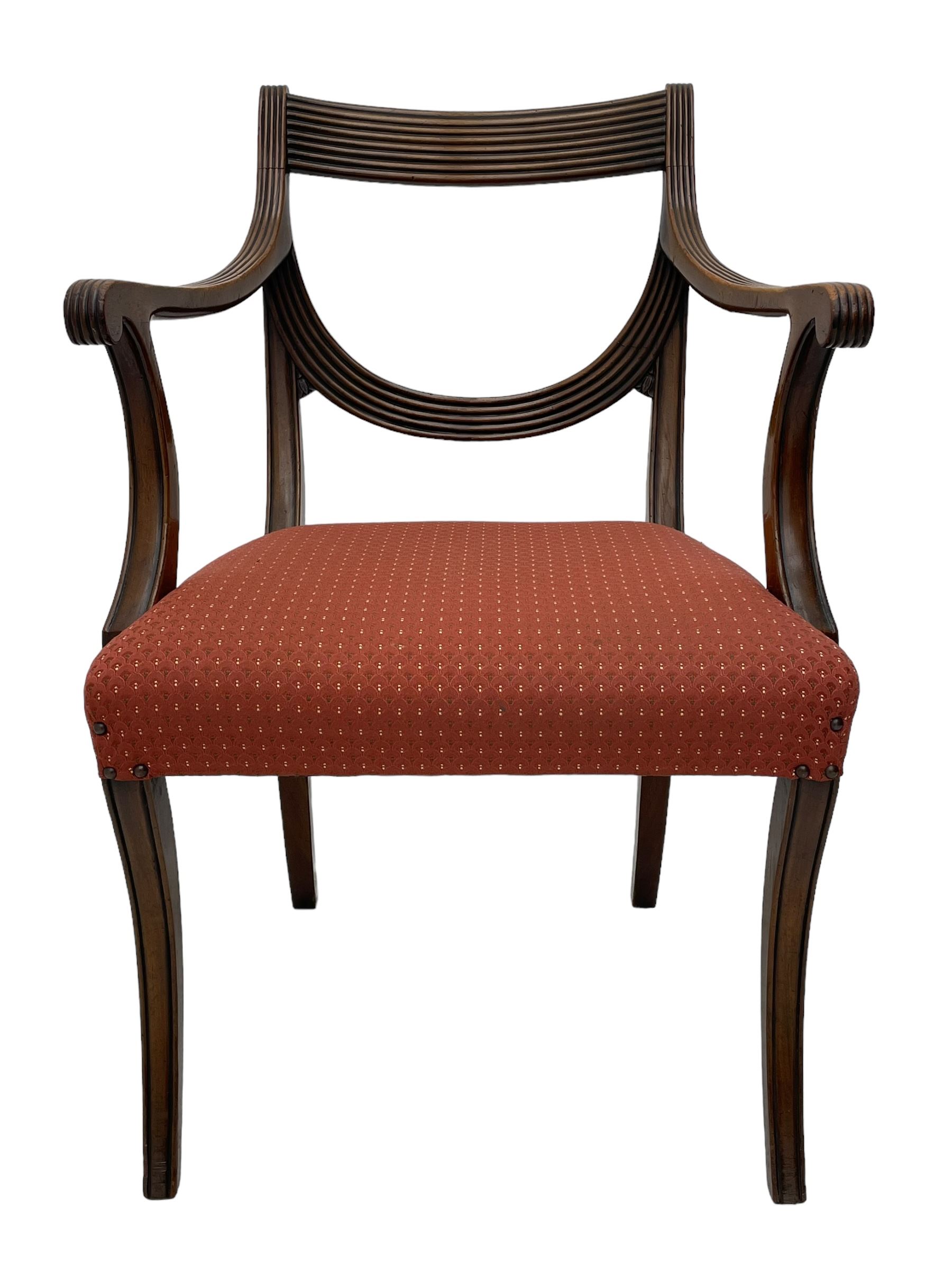 Set of six (4+2) George III design mahogany dining chairs, curved reed moulded bar back over curved and reeded middle rail, upholstered in red fabric with repeating pattern, on moulded sabre supports 