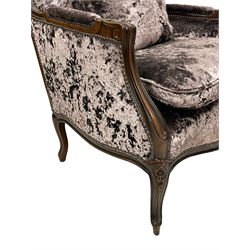 French design walnut framed wide-seat armchair, moulded frame carved with flowers, upholstered in purple crushed velvet, the lower rail carved with flowers and extending foliage, on cabriole feet