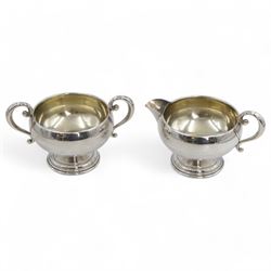 American silver sugar bowl and jug, each of circular form with C scroll handles and upon s...