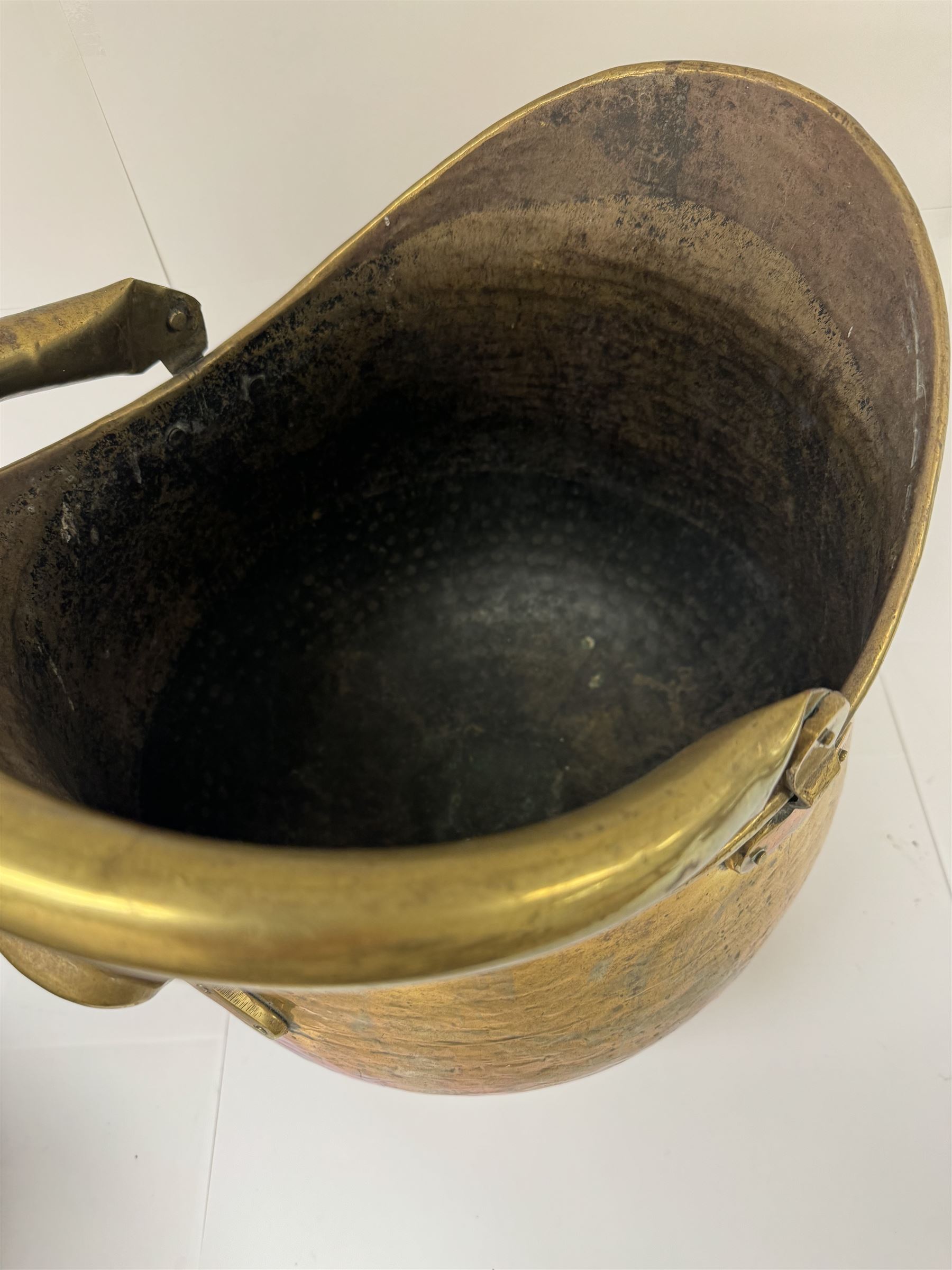 Middle eastern copper bucket, with chased and embossed band of animal decoration, together with a copper jardinière embossed with floral panels, copper plate with embossed leaf motif and two brass helmet shaped coal scuttles, bucket H26cm