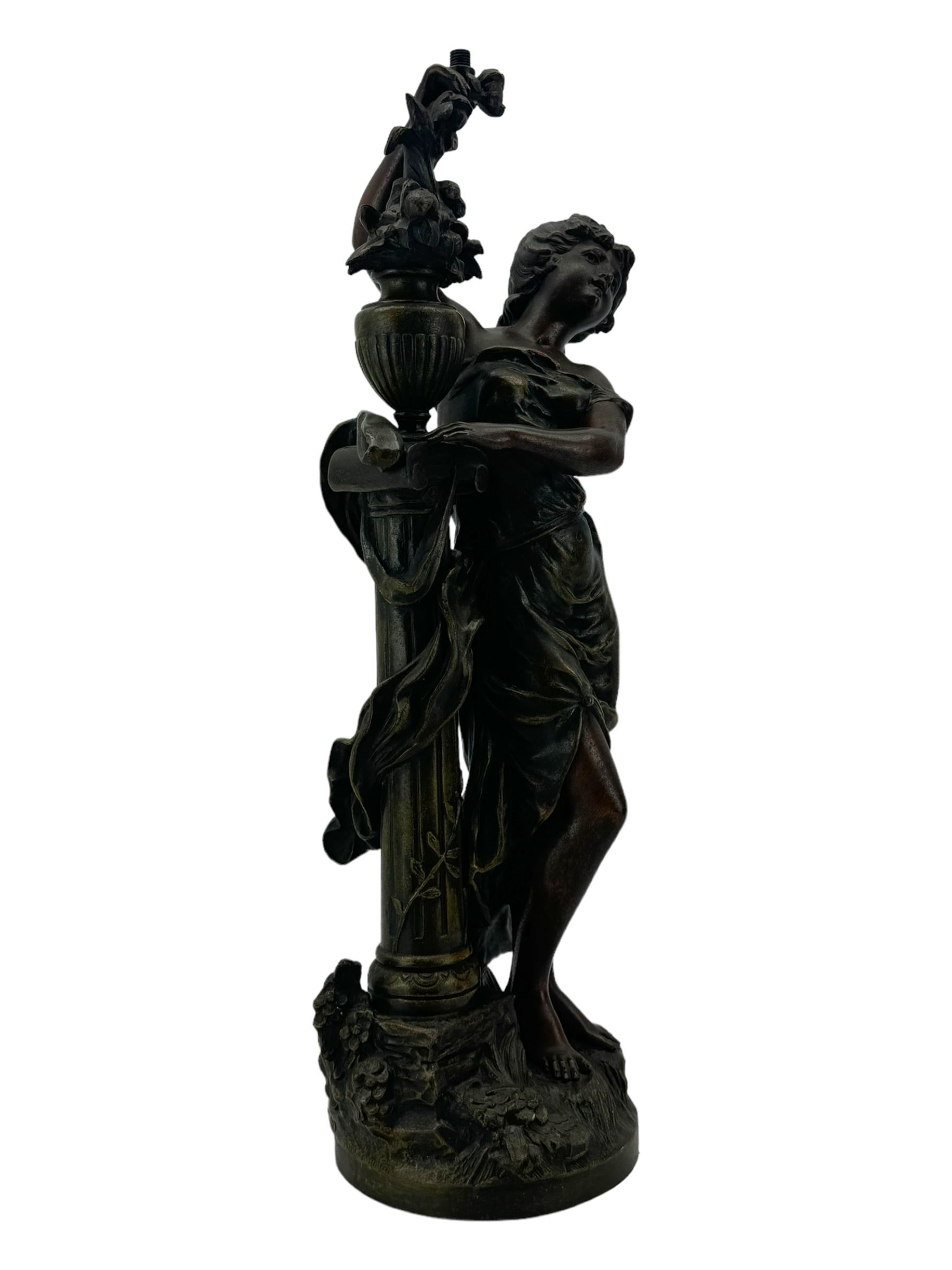 After L & F Moreau - Spelter table lamp in the form of a female figure next to a pedestal on circular naturalistic base H55cm