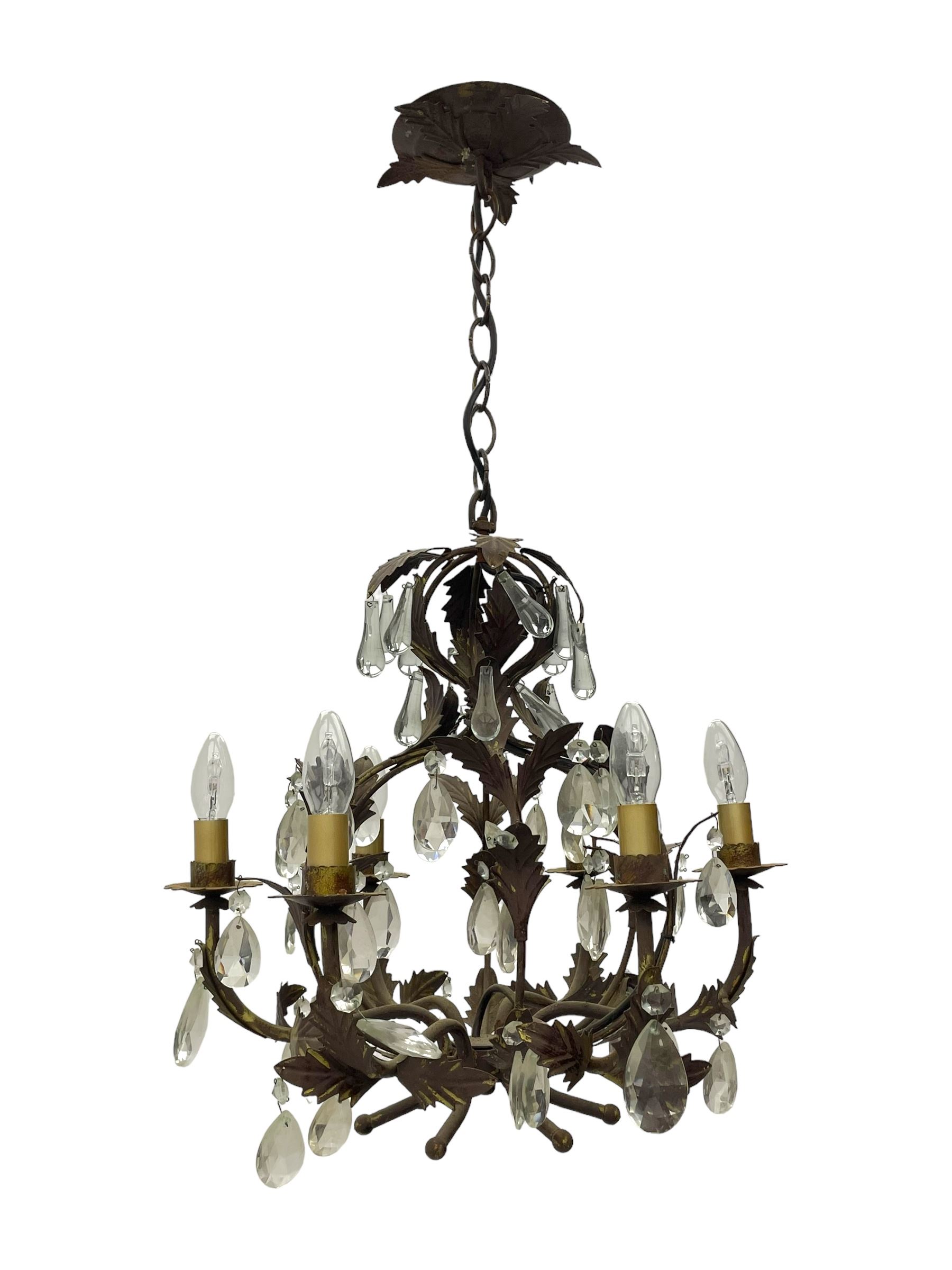 Early 20th century wrought metal chandelier, of scrolled form with six branches, decorated with leafage and glass pendants 