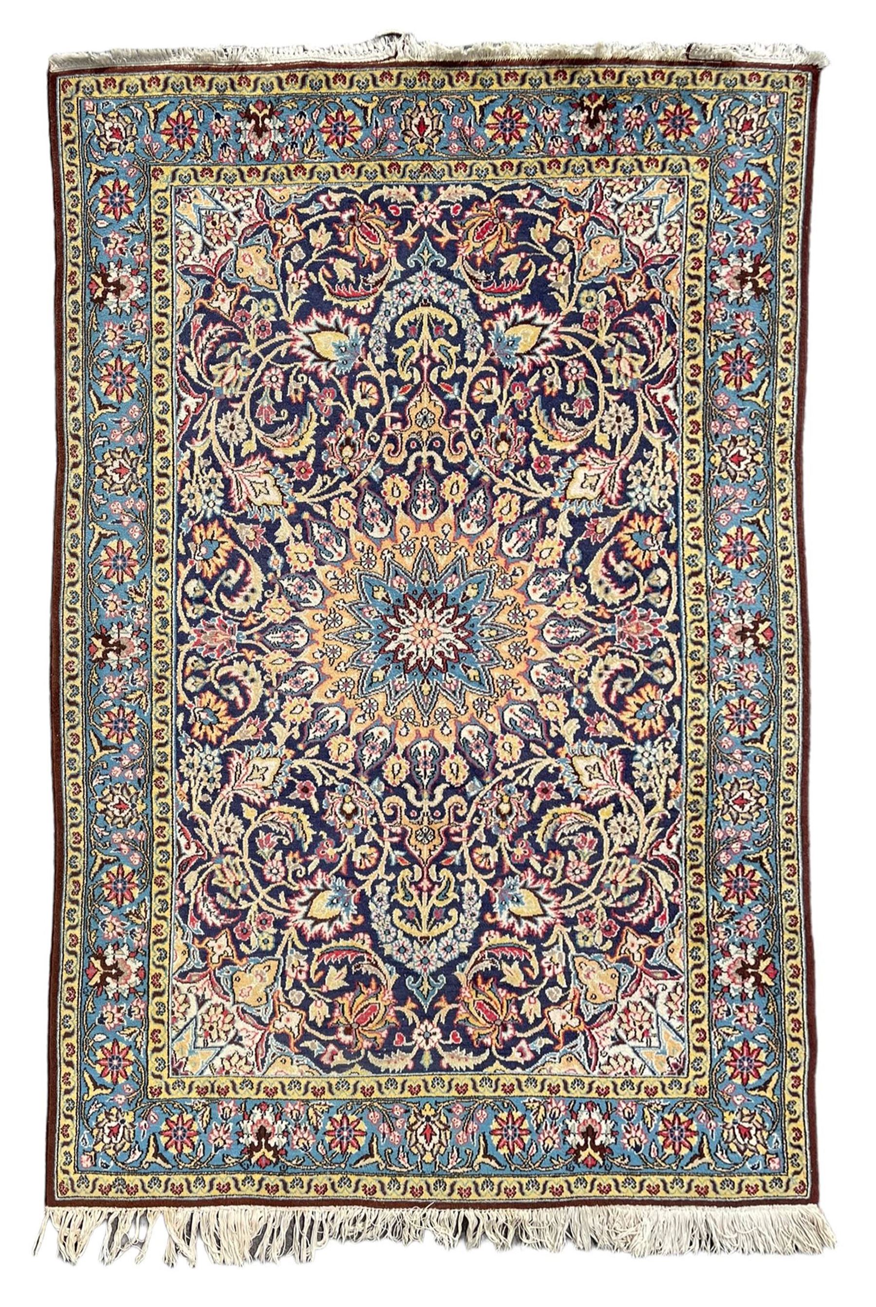 Persian indigo ground rug, overall arabesque design, central multi-point medallion surrounded by scrolling leafy branches and palmettes, the border decorated with repeating stylised plant motifs within guard stripes 