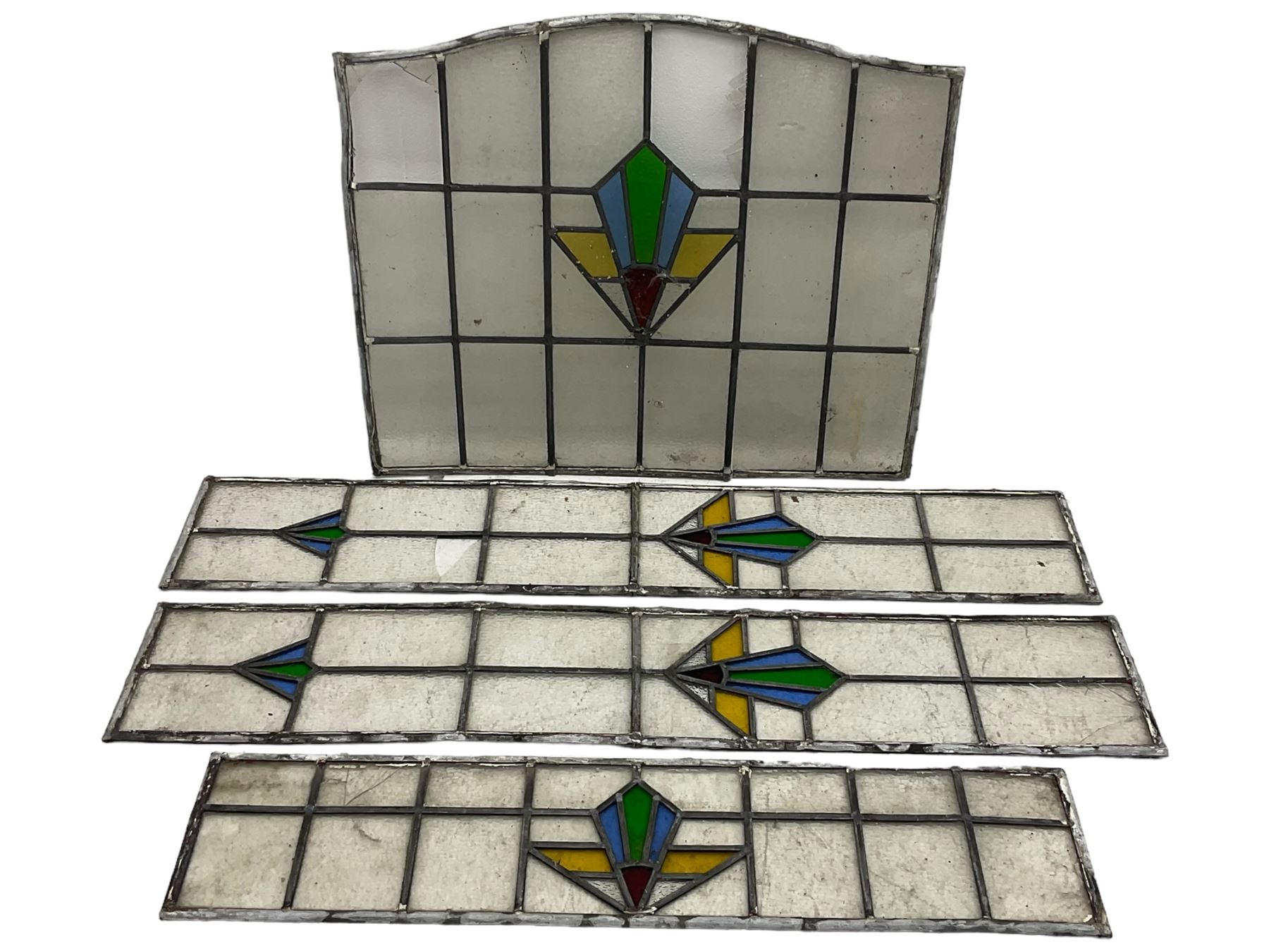 Four early 20th century stained glass and leaded windows, Art Deco design in blue, green, gold and red, largest 67 x 57cm, smallest 19 x 85cm. 