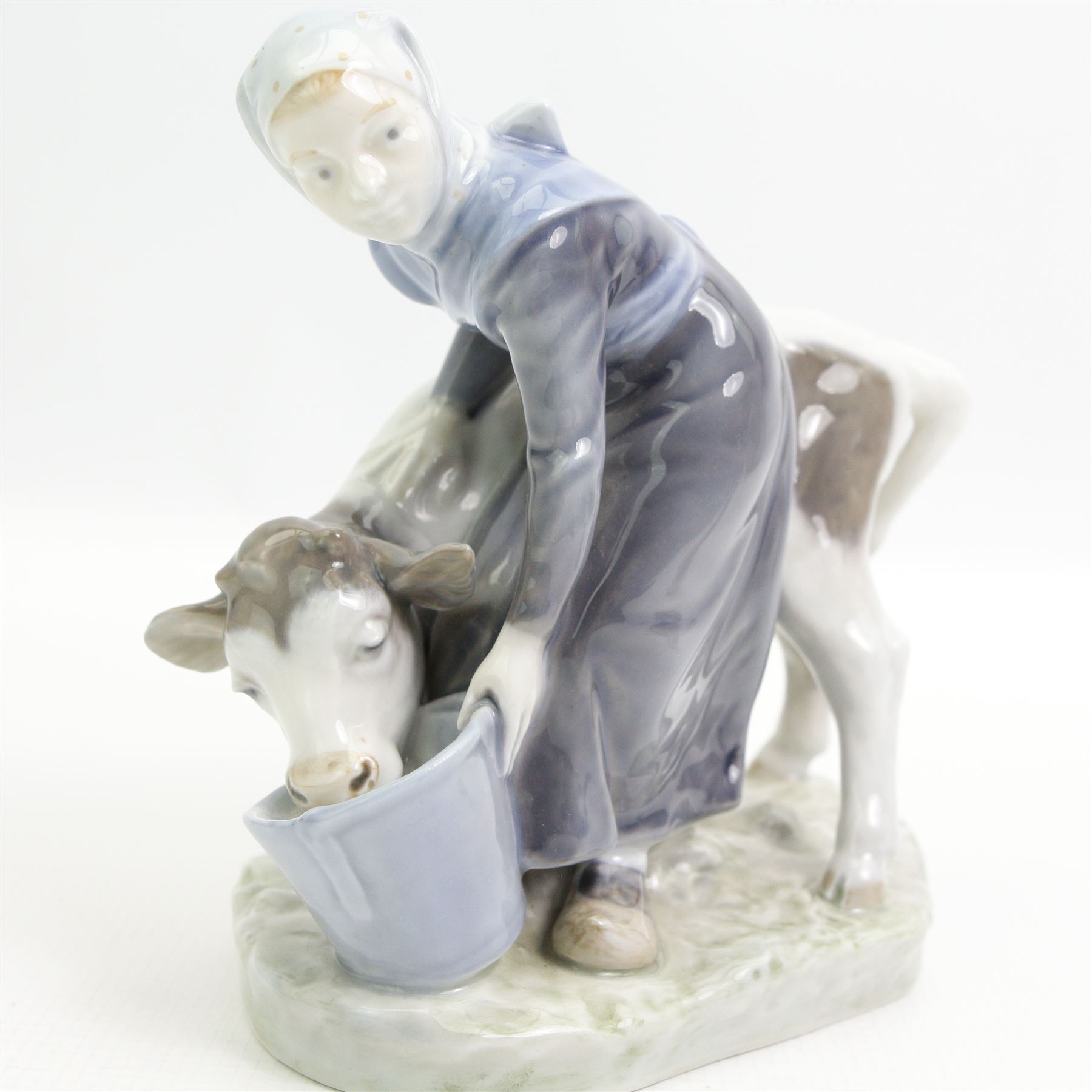 Royal Copenhagen figure of a girl feeding a calf No.799 H16cm, Copenhagen cobalt blue vase decorated with crocus H12cm, Copenhagen penguin No.3003 and a Bing & Grondahl pig